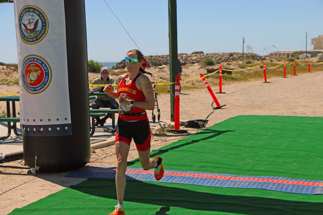 Marine Corps Capt. Mollie Geyer of MCB Camp Pendleton, California crosses the finish line winning the women's division of the 2023 Armed Forces Triathlon Championship hosted by Naval Base Ventura County, California on April 1.  The Armed Forces Championship features teams from the Army, Marine Corps, Navy (with Coast Guard runners), and Air Force (with Space Force Runners).  Department of Defense Photo by Mr. Steven Dinote - Released.