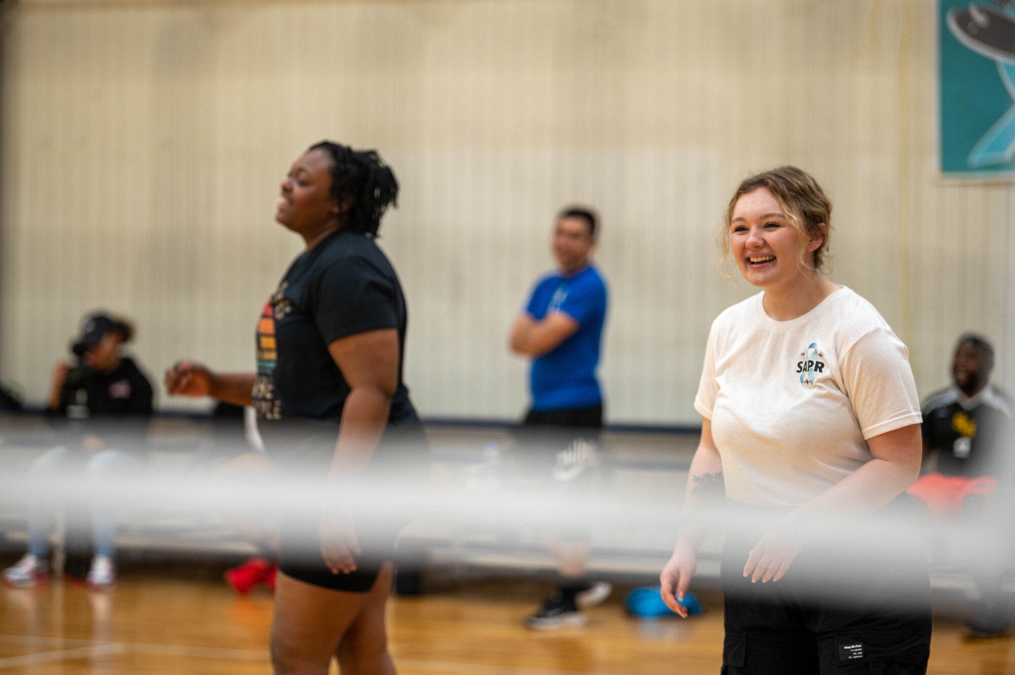 Two women smile during a volleyball tournament.