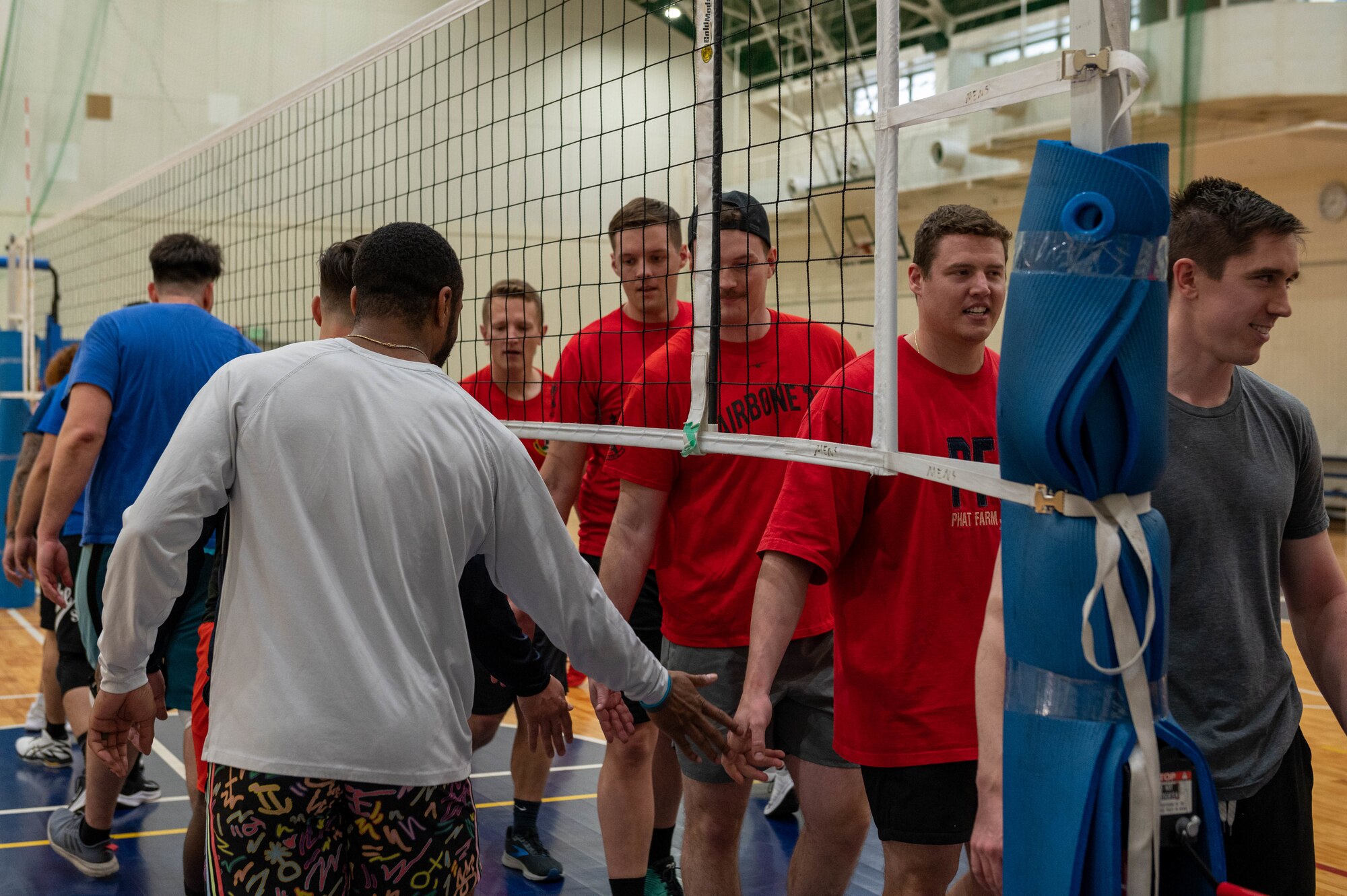 Airmen high-five each other following a match at a volleyball tournament.