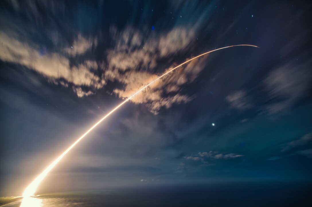 The fiery trail of a missile target launch is seen at twilight.