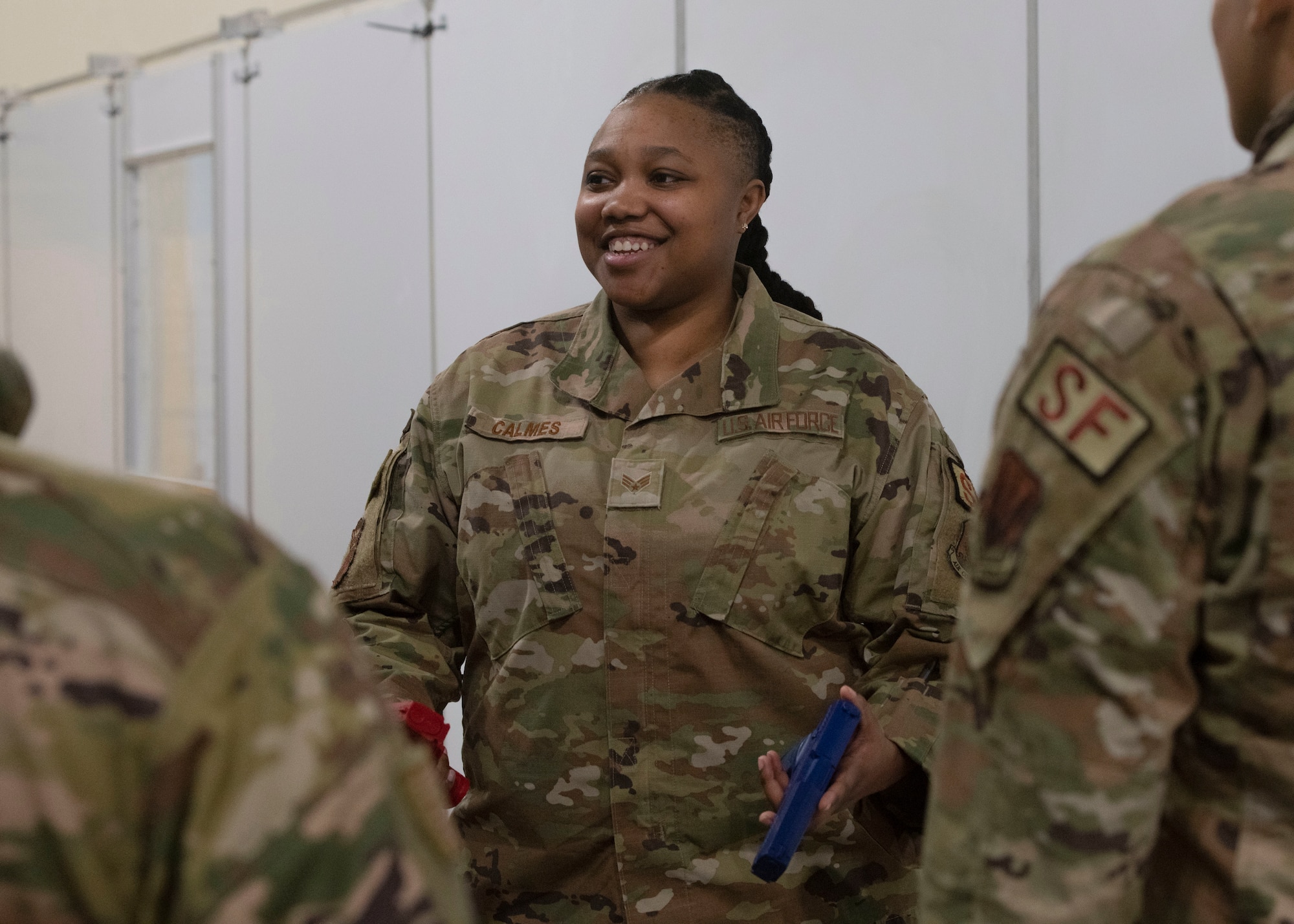 Woman smiling at foreground airmen