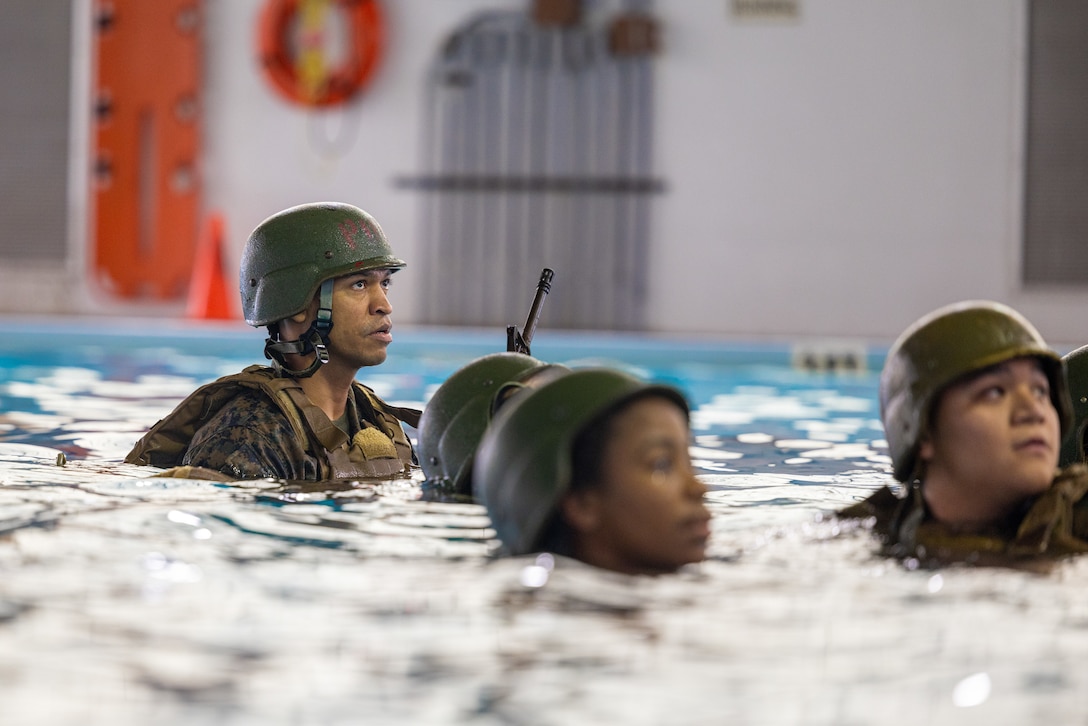 U.S. Marines focus on the instructions given before beginning their underwater gear shed event at the Mainside Pool, Marine Corps Air Station Cherry Point, North Carolina, March 22,2023. The Marines participated in a total of five events to ensure combat readiness for surviving any waterborne accident. (U.S. Marine Corps photo by Lance Cpl. Matthew Williams)