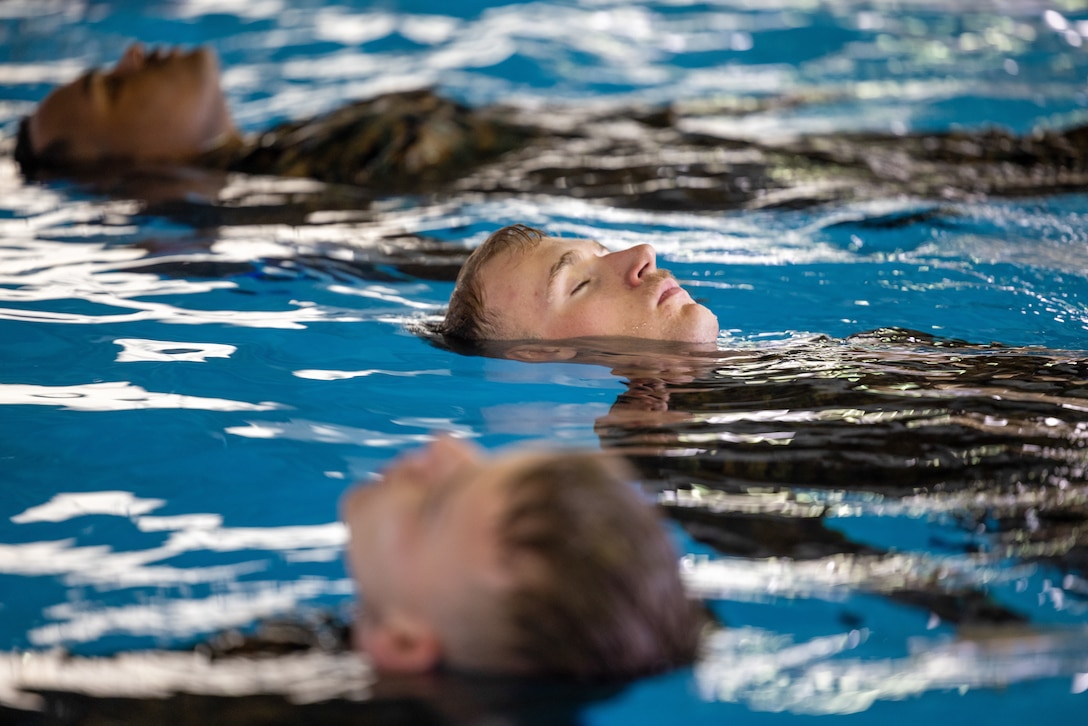 U.S. Marines focus on the instructions given before beginning their underwater gear shed event at the Mainside Pool, Marine Corps Air Station Cherry Point, North Carolina, March 22,2023. The Marines participated in a total of five events to ensure combat readiness for surviving any waterborne accident. (U.S. Marine Corps photo by Lance Cpl. Matthew Williams)