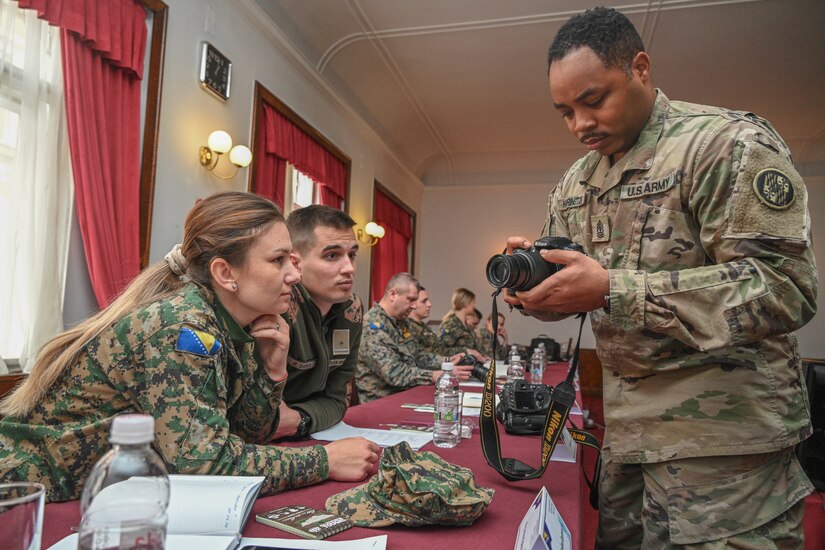 U.S. Army 1st Sgt. Thaddeus Harrington, 29th Mobile Public Affairs Detachment, Maryland National Guard, instructs Armed Forces of Bosnia and Herzegovina (AFBiH) service members on camera functionality during a public affairs workshop March 27, 2023, at the Army Hall in downtown Sarajevo. Subject matter experts from the MDNG demonstrated photo, video, writing and social media techniques.