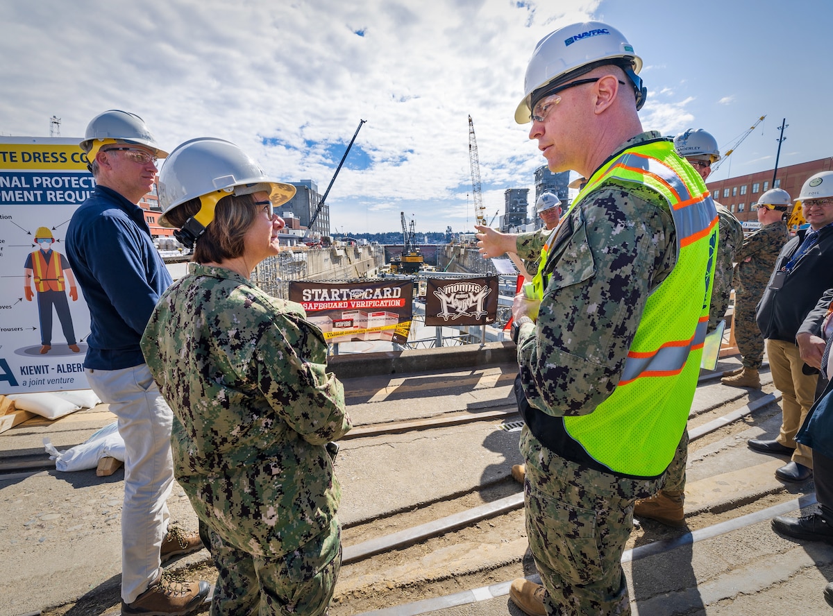 The Honorable Erik Raven, Under Secretary of the Navy, and Adm. Lisa Franchetti, Vice Chief of Naval Operations, discuss ongoing seismic mitigations at Dry Dock 4 at Puget Sound Naval Shipyard & Intermediate Maintenance Facility in Bremerton, Washington, March 29, 2023. Raven and Franchetti met with shipyard leadership during their visit to discuss infrastructure upgrades and work planned as part of the Shipyard Infrastructure Optimization Program, the Navy’s once-in-a-century investment to reconfigure, modernize and optimize its four aging public shipyards. (U.S Navy Photo by Wendy Hallmark)