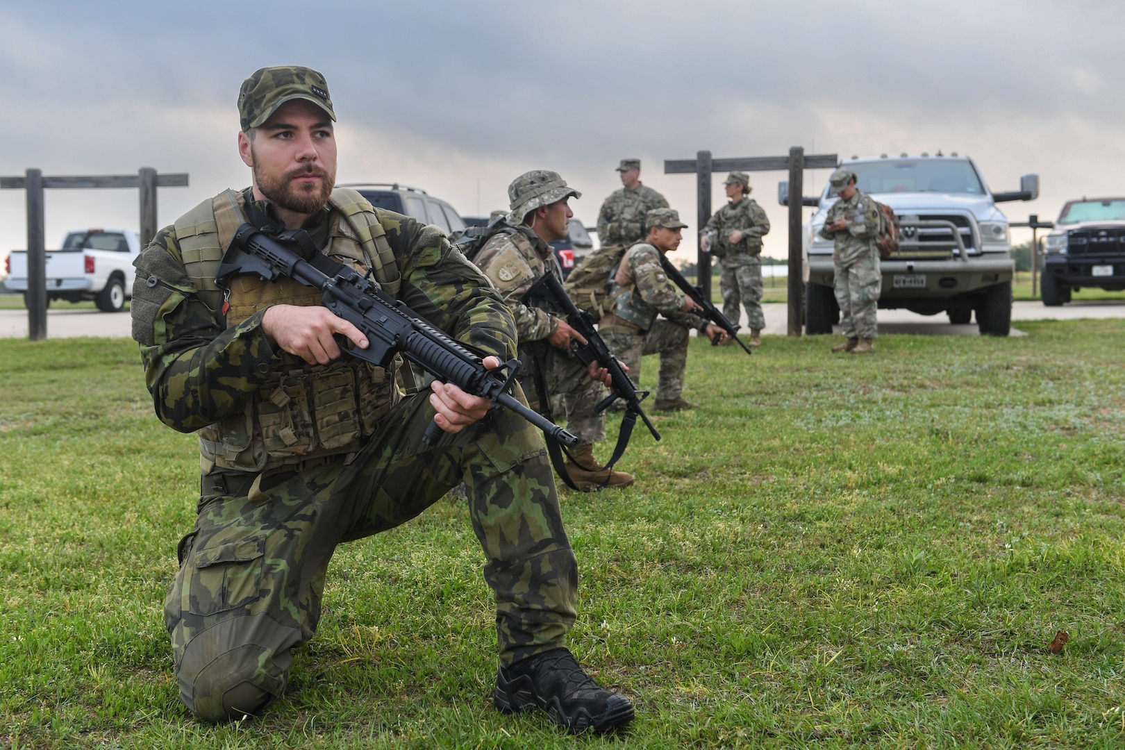 Staff Sgt. Maxim Mojzis, Czech army, kneels alongside Chilean armed forces in preparation for the M-4 qualifying event during the Texas Military Department Best Warrior Competition at Camp Swift, Texas, March 31, 2023. The friendly, six-day competition challenged service members on professional military knowledge, marksmanship, obstacle course and land navigation.