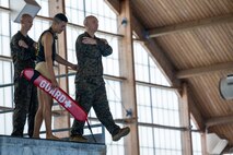 A U.S. Marine steps off the high dive platform at the Mainside Pool during basic water survival training, Marine Corps Air Station Cherry Point, North Carolina, March 22,2023. The Marines participated in a total of five events to ensure combat readiness for surviving any waterborne accident. (U.S. Marine Corps photo by Lance Cpl. Matthew Williams)