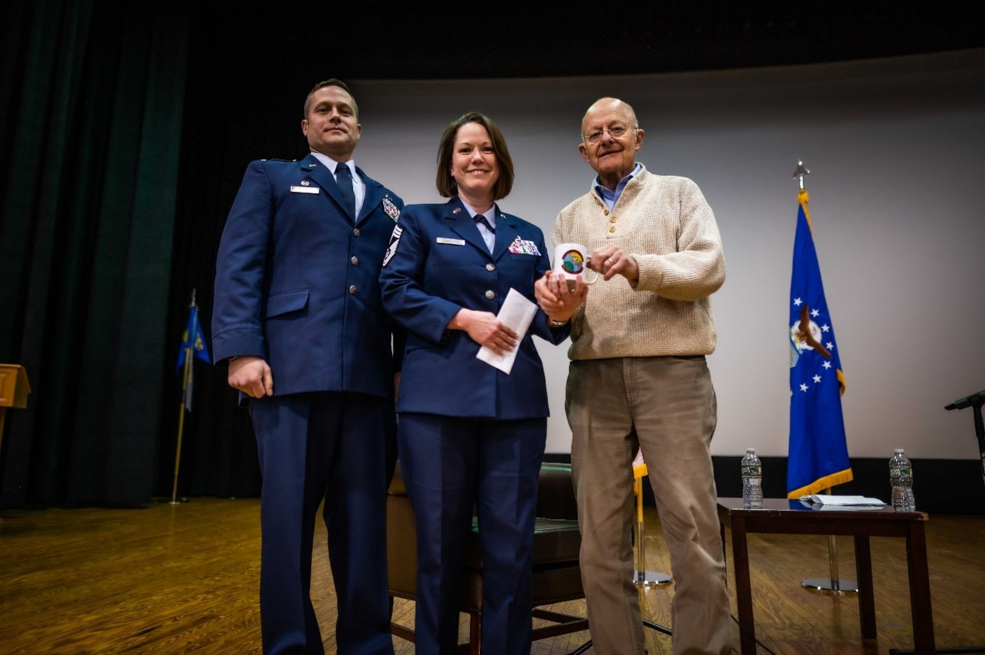 Lt. Col. John Durkee, 16th Intelligence Squadron commander (left), and Chief Master Sgt. Rebecca Casanova, 16 IS Senior Enlisted Leader (center), present a 16 IS mug and coin to Lt. Gen. (Ret.) James Clapper during the Feb. 4, 2023 unit training assembly. Clapper, former director of national intelligence, shared leadership lessons from his career to Airmen from both the 16th and 512th Intelligence Squadrons earlier that day.