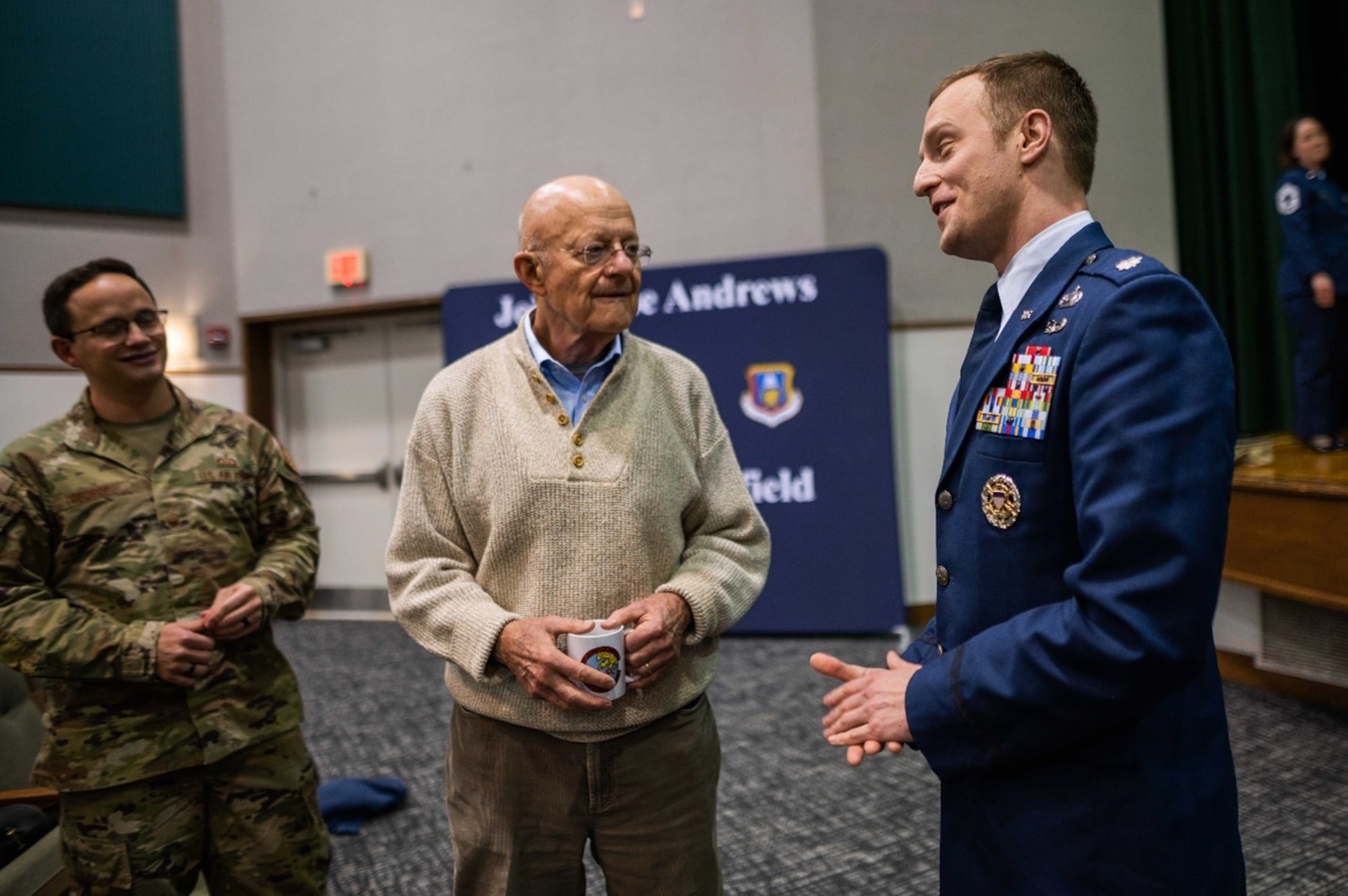 Master Sgt. Patrick George, 16th Intelligence Squadron first sergeant (left), and Lt. Col. Philip Caruso, 16 IS director of operations (right) talk with Lt. Gen. (ret.) James Clapper, former director of national intelligence, after he shared his career experiences during a speaking event with the men and women of the 16th and 512th Intelligence Squadrons.