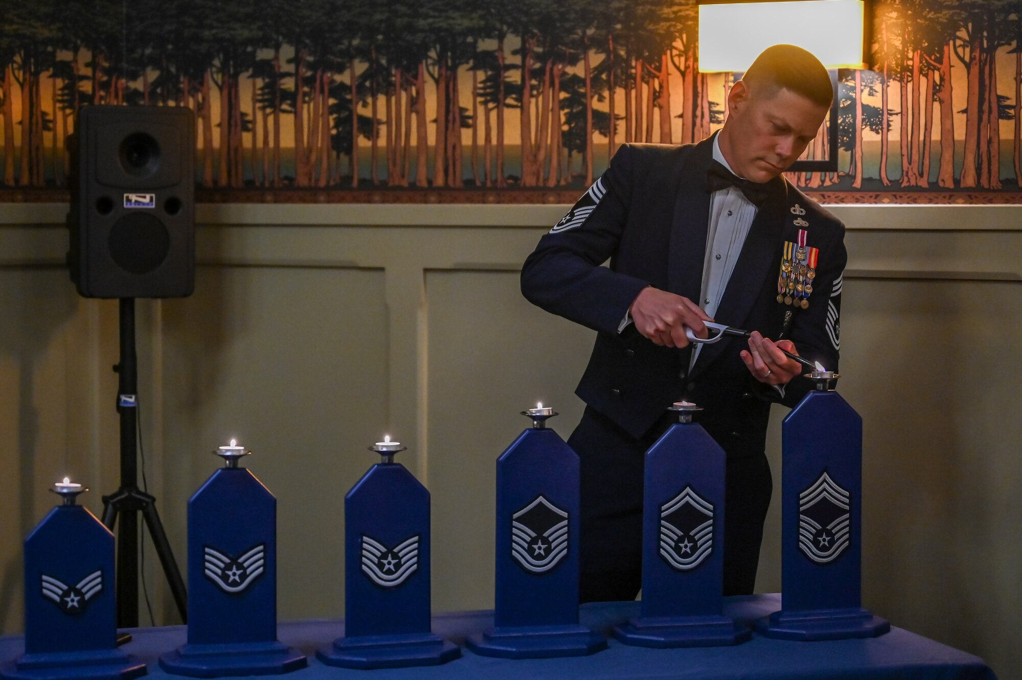 Chief Master Sgt. Brett Kemp, 649th Munitions Squadron, lights the candle representing the rank of chief master sergeant during Hill Air Force Base's Chief Induction Ceremony