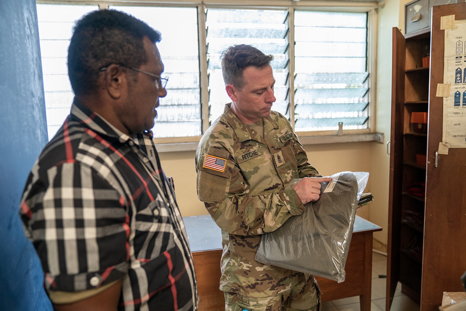 First Sgt. Aaron Ritchie, right, 64th Troop Command’s senior supply sergeant and sustainment noncommissioned officer (NCO) representative, asks a Papua New Guinea Defence Force Soldier about serial numbers for supply items March 24, 2023, at Murray Barracks in Port Moresby, Papua New Guinea. Six NCOs conducted an information exchange with Papua New Guinea Defence Force counterparts March 20-27 as part of the State Partnership Program.
