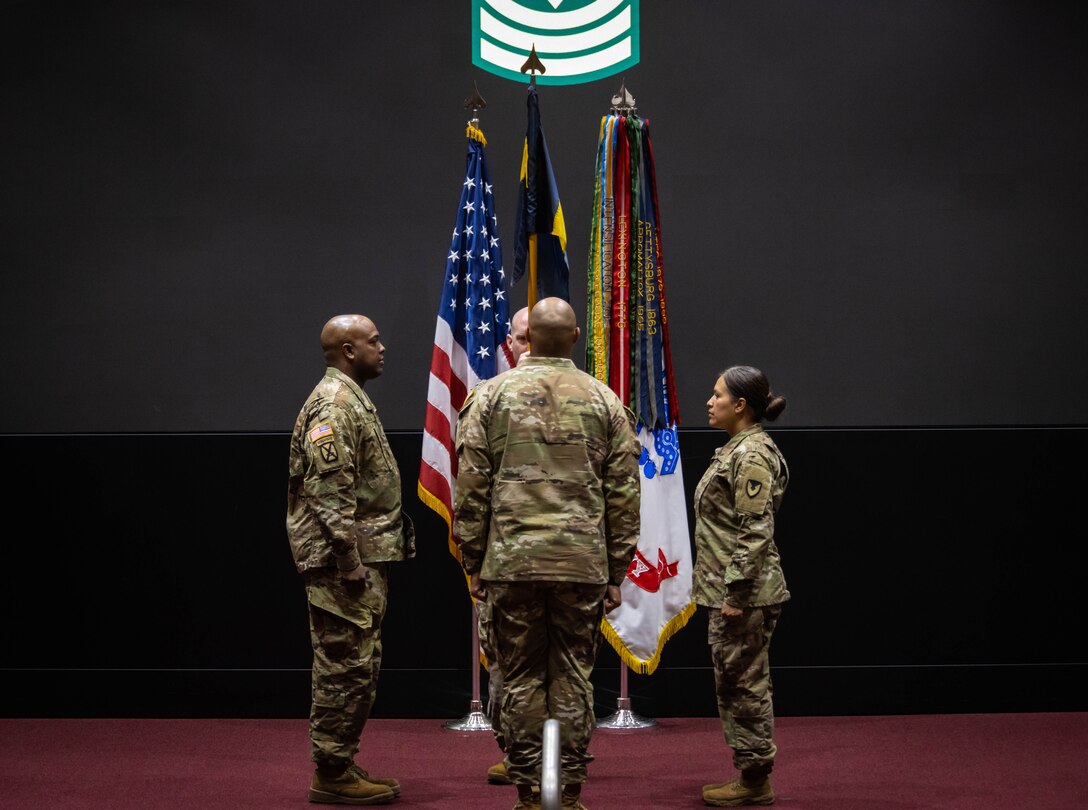 Three Soldiers on stage during a ceremony.