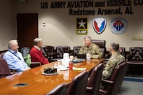 Four men sitting at conference table.