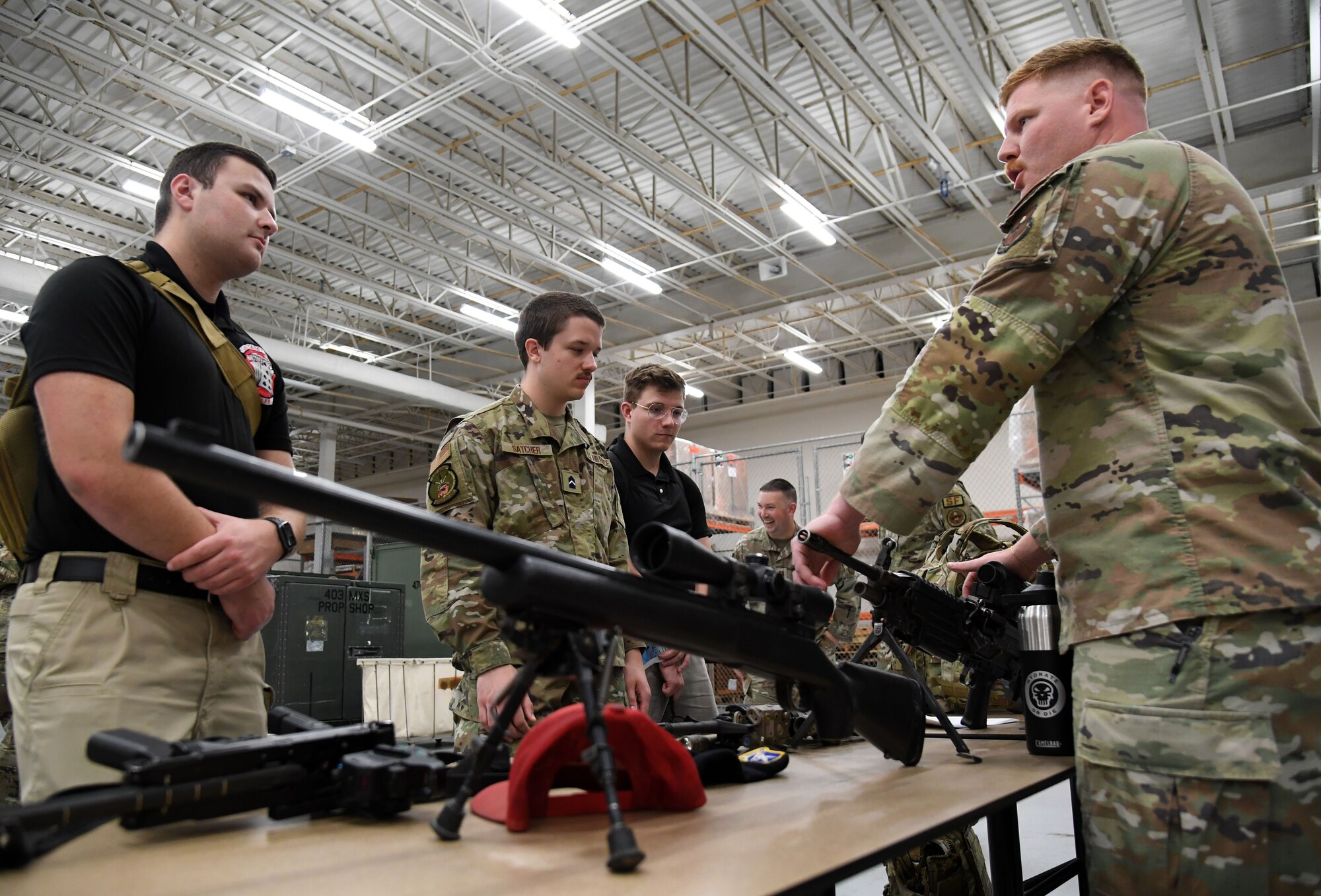 U.S. Air Force Staff Sgt. Anthony Ryan, 81st Security Forces Squadron armory NCO in charge, shows military weapons to Air Force ROTC cadets during Pathways to Blue inside the Roberts Consolidated Aircraft Maintenance Facility at Keesler Air Force Base, Mississippi, March 31, 2023.