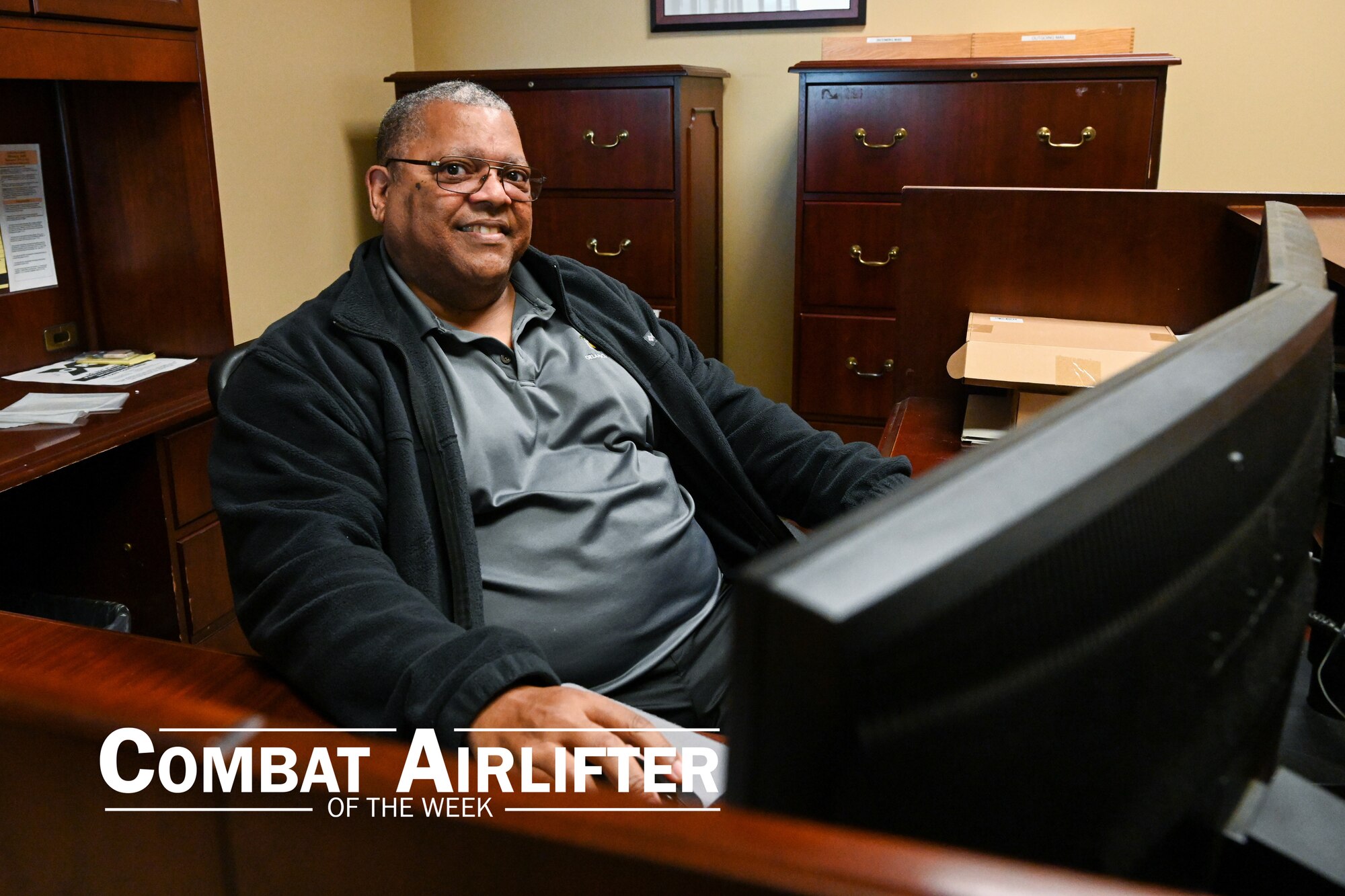 a man sits a computer desk