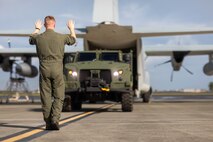 A U.S. Marine with Marine Aerial Refueler Transport Squadron 153 guides a joint light tactical vehicle into the cargo hold of a KC-130J Hercules during a training event, Marine Corps Air Station Kaneohe Bay, Marine Corps Base Hawaii, March 21, 2023. The training was conducted to familiarize Marines with procedures for loading a JLTV onto a cargo aircraft. (U.S. Marine Corps photo by Cpl. Christian Tofteroo)