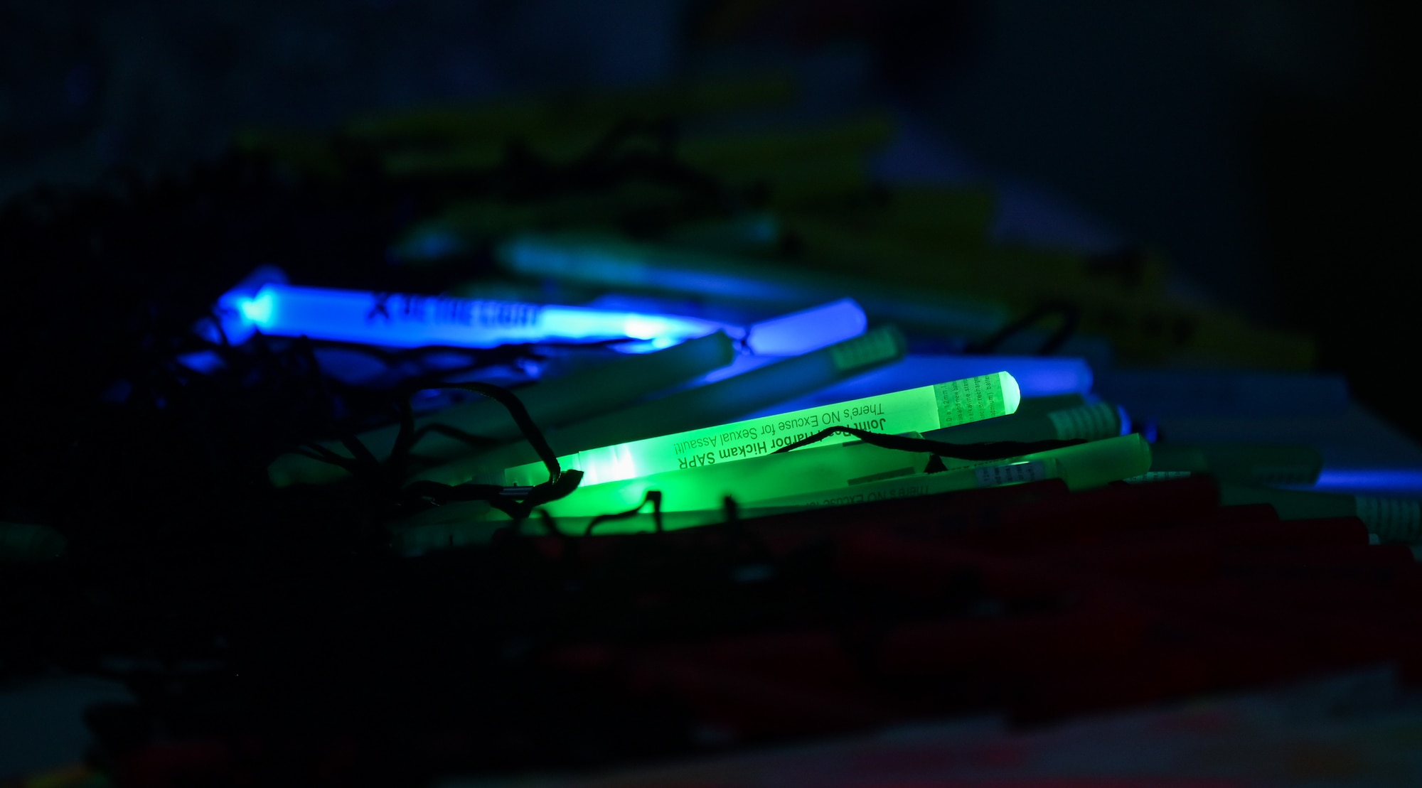 Glow sticks are displayed at a 15th Wing Sexual Assault Awareness Prevention and Response booth during a Sexual Assault Prevention Month glow run at the Missing Man Trail on Joint Base Pearl Harbor-Hickam, Hawaii, Mar. 31, 2023. The run was held to increase awareness of sexual assault within the military and provide helpful resources. (U.S. Air Force photo by Staff Sgt. Alan Ricker)