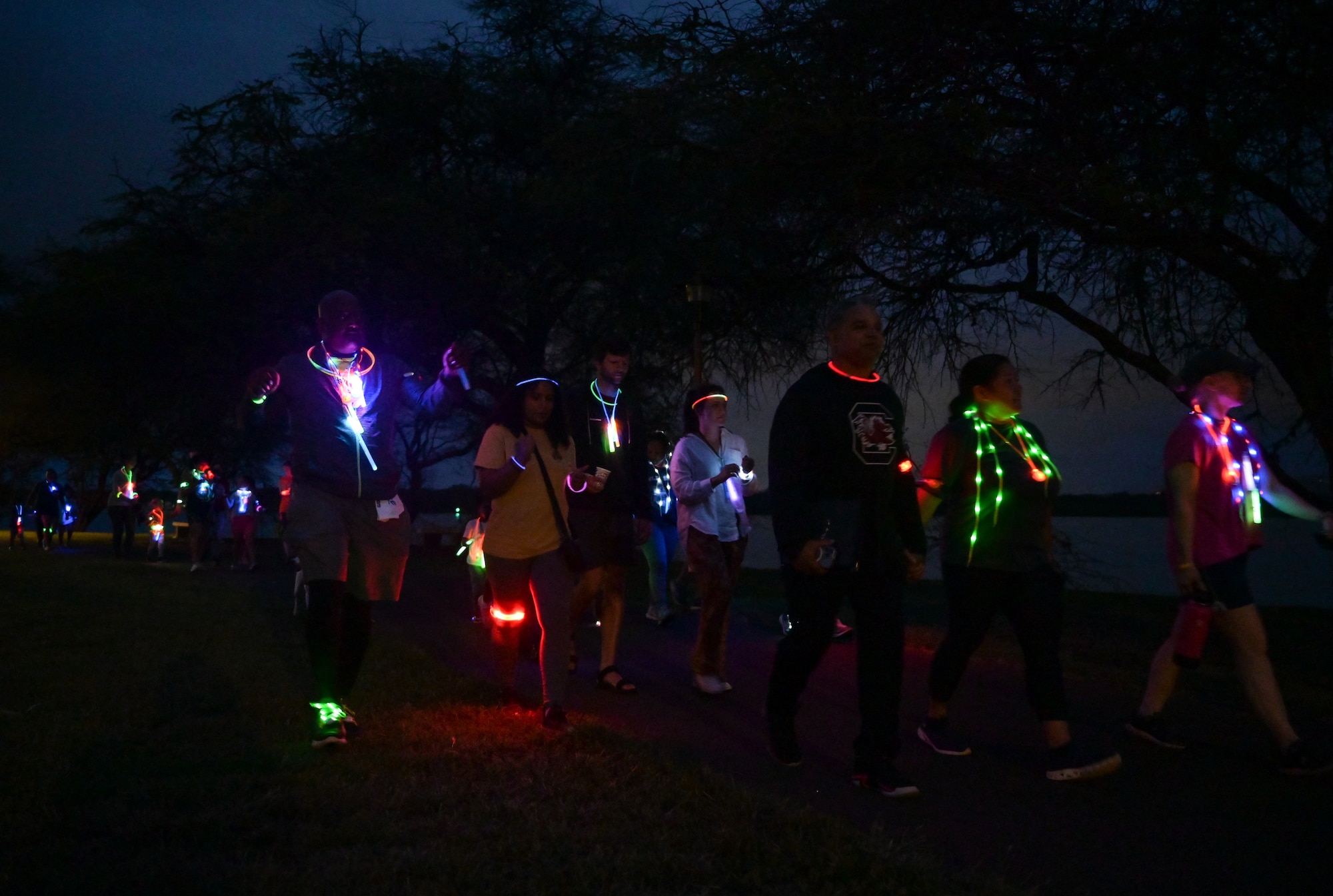 Runners race on the Missing Man Trail during a Sexual Assault Awareness Prevention Month glow run on Joint Base Pearl Harbor-Hickam, Hawaii, Mar. 31, 2023. The run was held to increase awareness of sexual assault within the military and provide helpful resources. (U.S. Air Force photo by Staff Sgt. Alan Ricker)