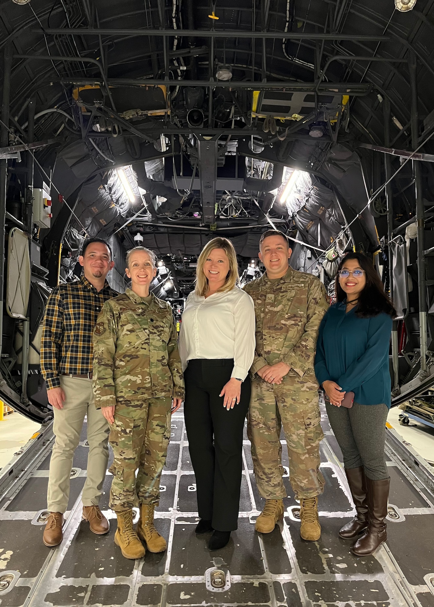 From left: Aeromedical and Operational Clinical Psychology, or AOCP, branch members Dr. Ivan Colin-Rivera, Lt. Col. Kristen Galloway, Dr. Rachael Martinez, Tech. Sgt. Christopher Thompson and Somtirtha Bag at a team event in the U.S. Air Force School of Aerospace Medicine, or USAFSAM, High Bay at Wright-Patterson Air Force Base, Ohio, March 17, 2023. AOCP consults with units across the Air Force to provide evidence-based psychological support for members. AOCP is a branch of USAFSAM, part of the Air Force Research Laboratory’s 711th Human Performance Wing. USAFSAM’s High Bay has multiple aircraft bodies that allow personnel to train for aeromedical evacuation without taking flight. (U.S. Air Force photo / Jeremy Ward)