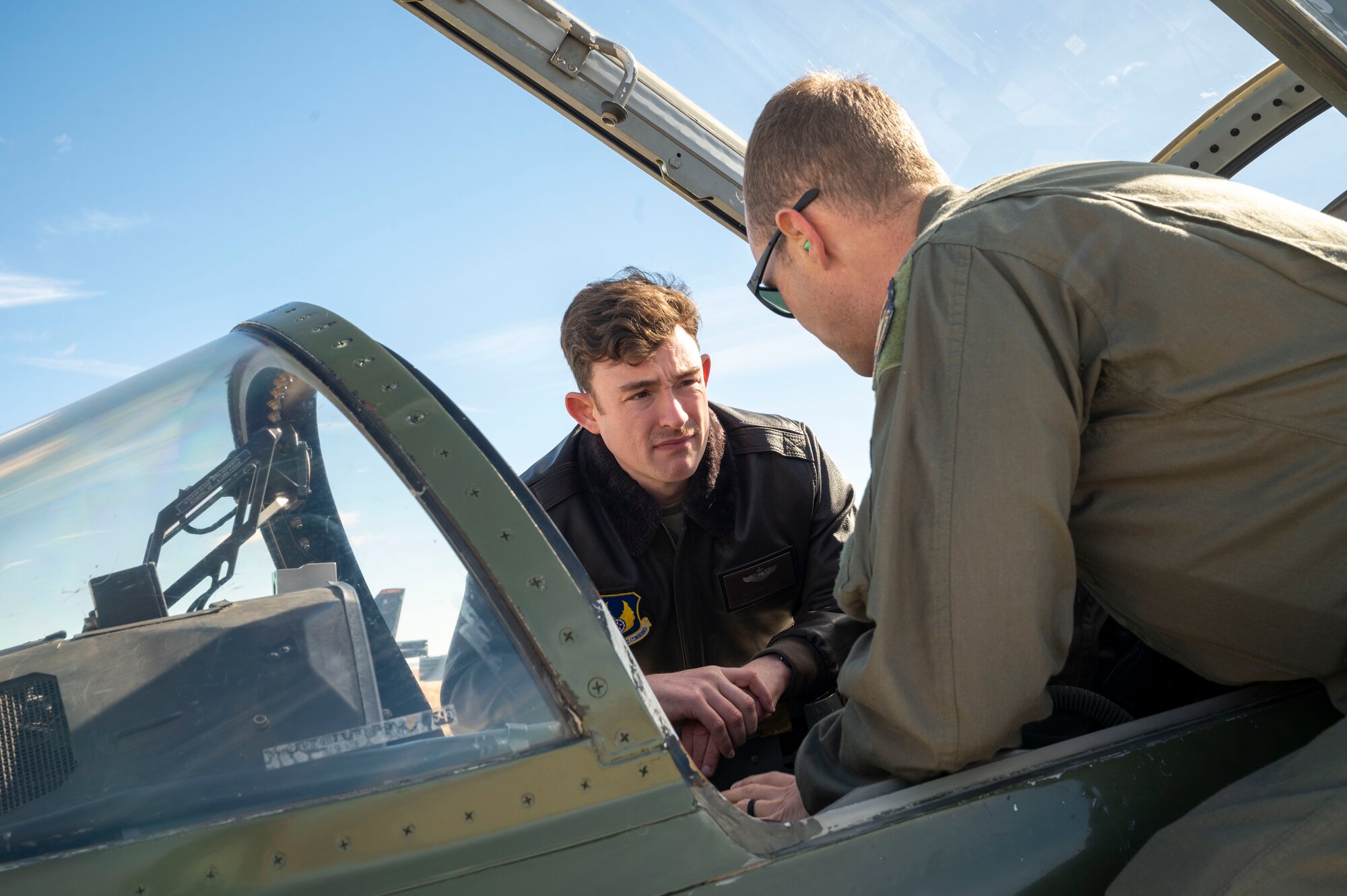 Maj. Matthew Daugherty, Project Pilot gets a lesson about the new GPS system "5tarboy" from Squadron Leader Stephen Tavener, Project Pilot (UK). "5tarboy" would more utilize the GPS L5 signal reception through a TACAN antenna that would be more accurate for navigation guidance.
