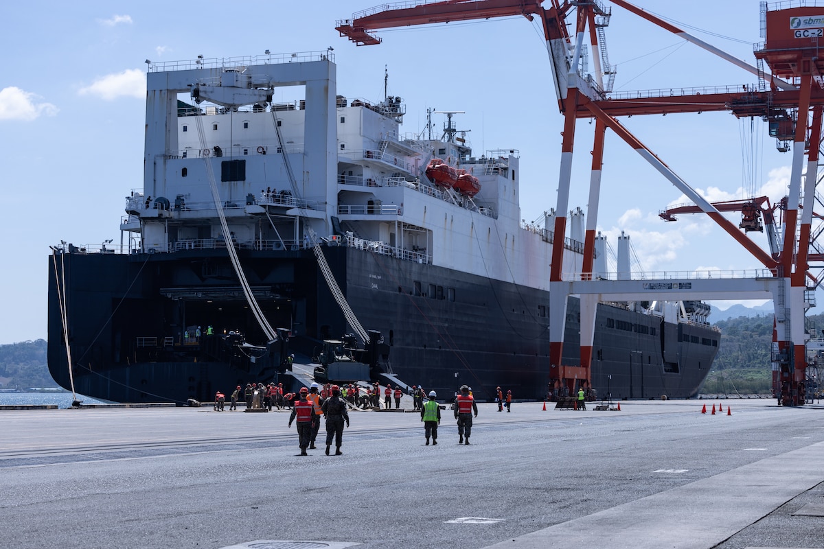 People mull around a docked ship.