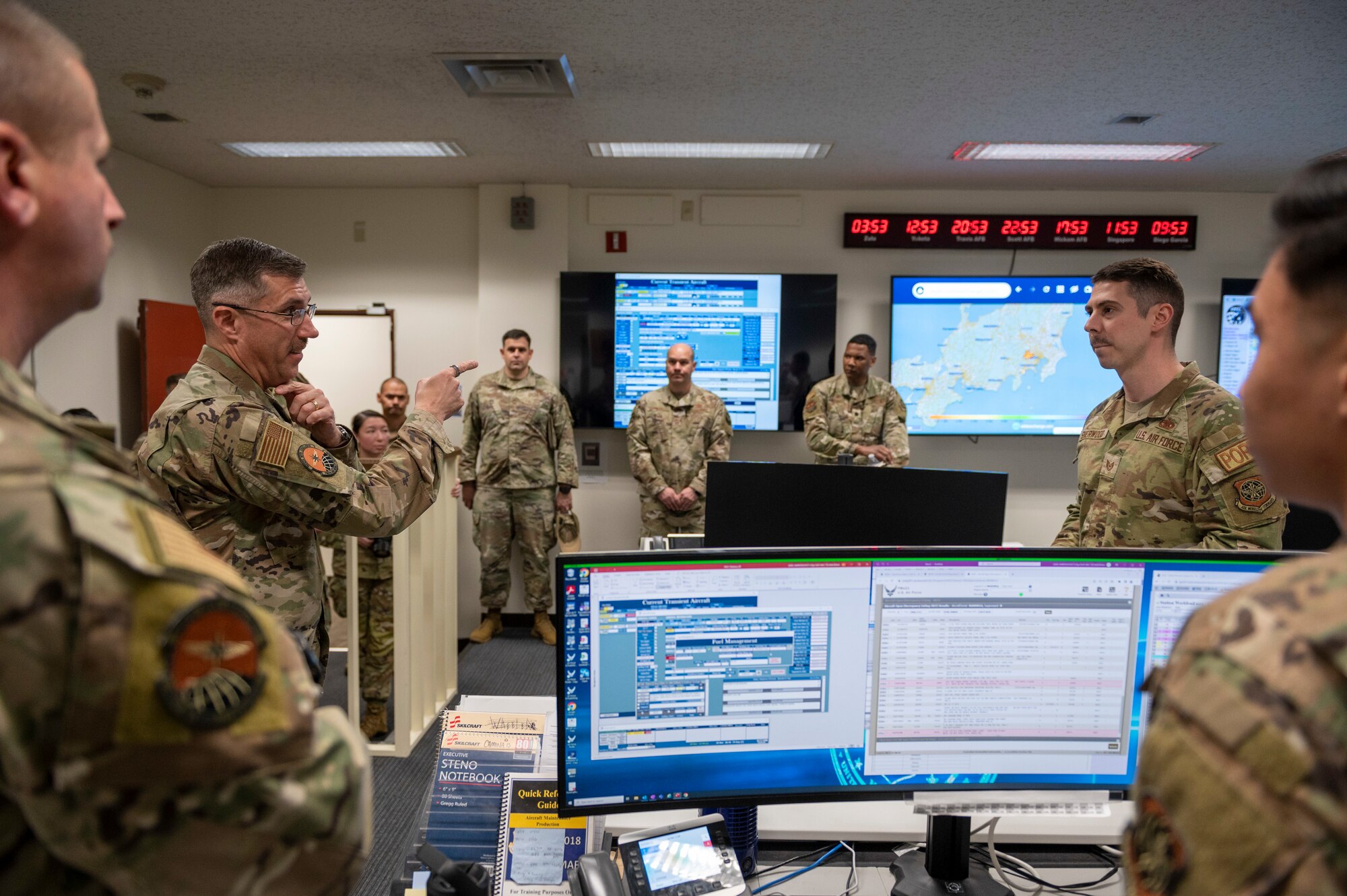 A general gestures to a tv encircled by other soldiers