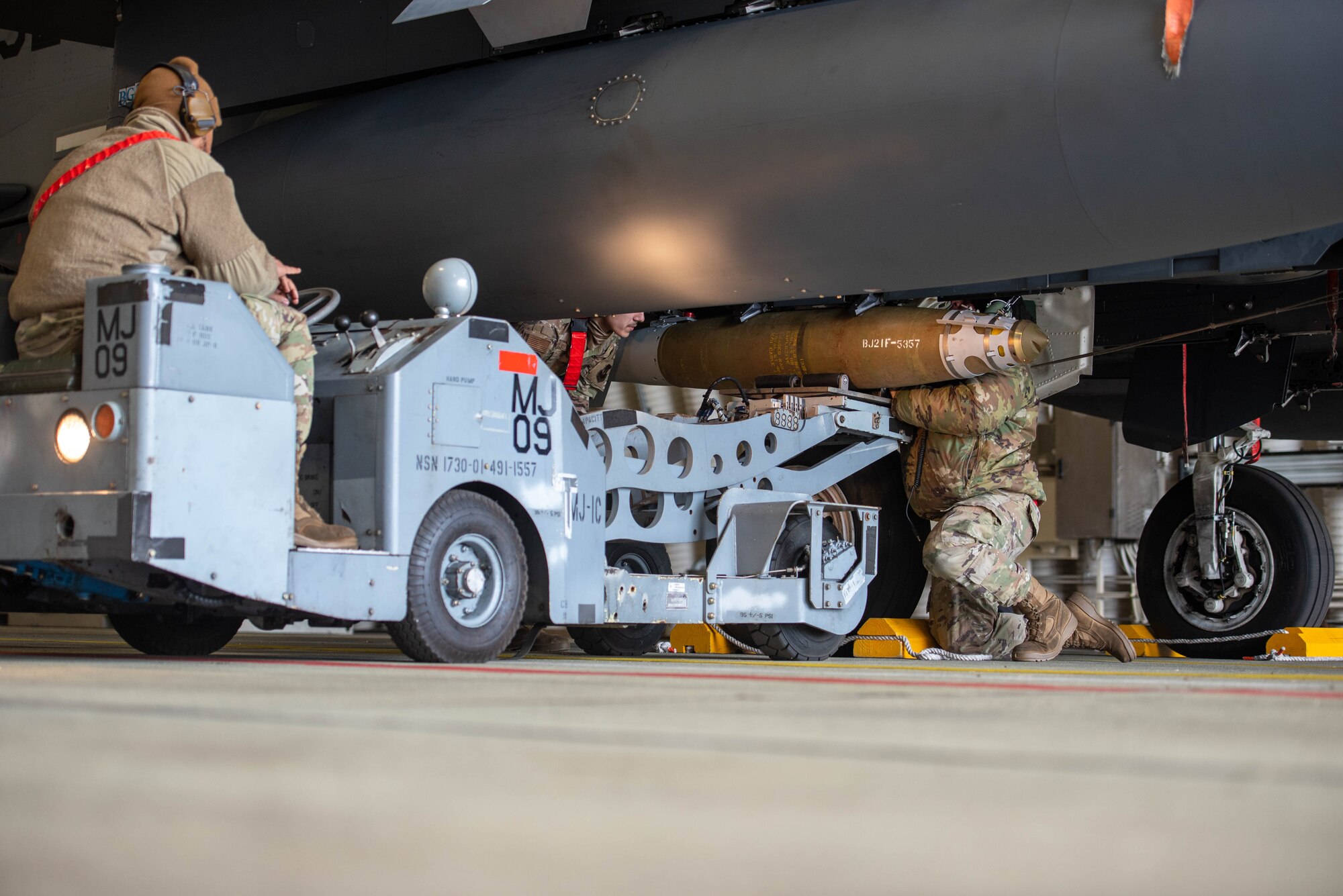 Airmen load munitions onto an aircraft.