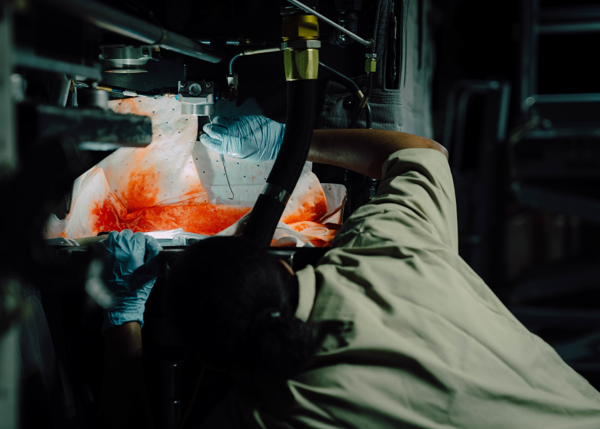 a person in military uniform perform maintenance on an aircraft