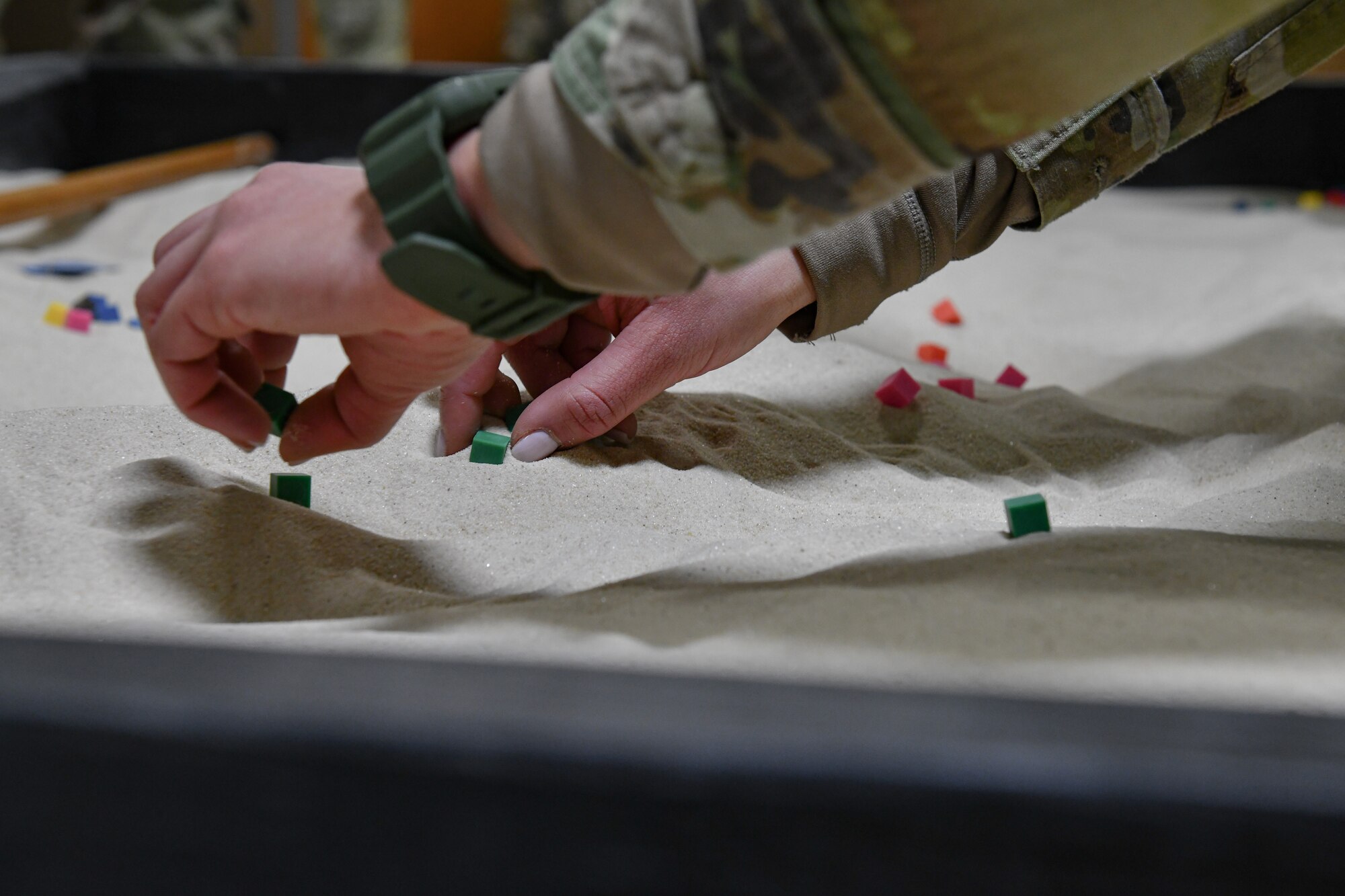 Senior Airman Brianna Clay, an Integrated Defense Leadership Course cadre member assigned to the 349th Security Forces Squadron, Travis Air Force Base, California, demonstrates land navigation movements using sand and cubes on March 14, 2023, at Youngstown Air Reserve Station, Ohio.