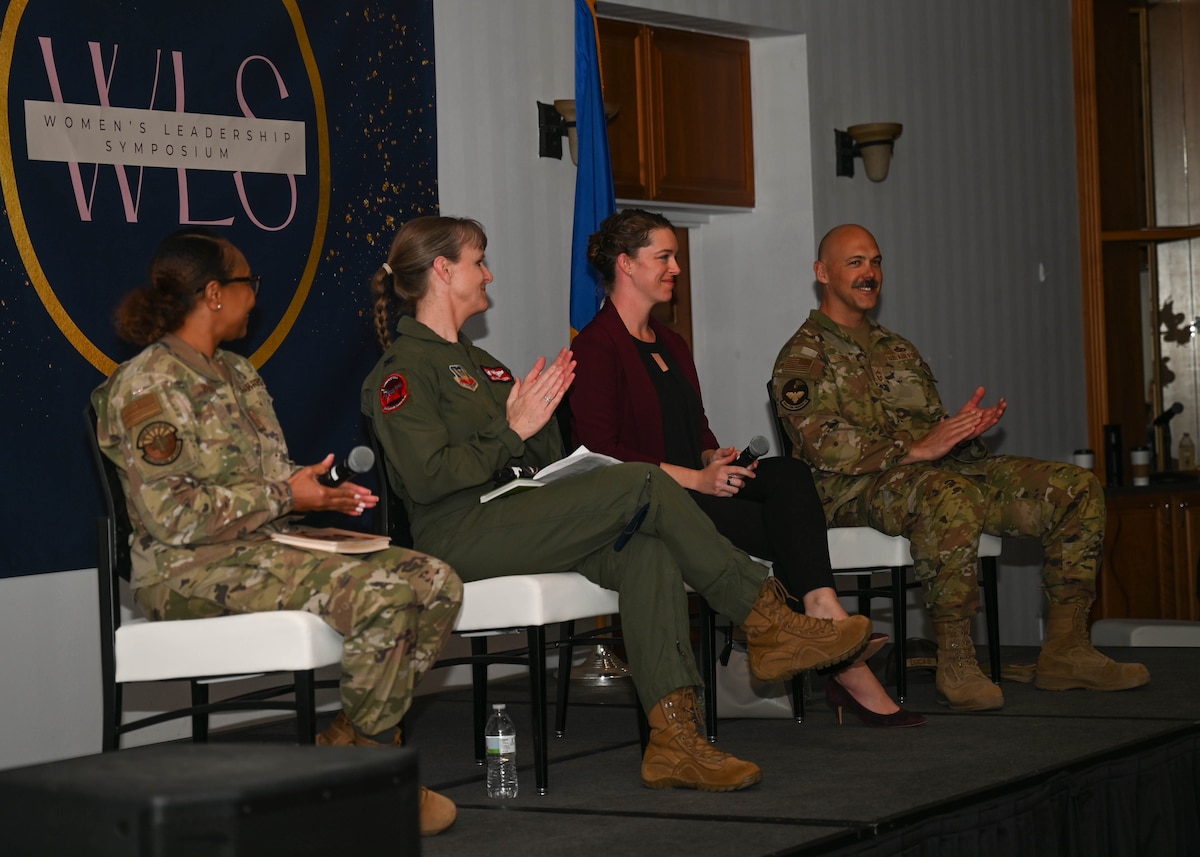 A photo of four people answering questions during a symposium.