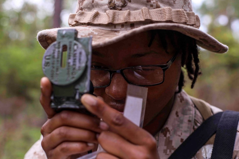 A recruit looks through a compass.