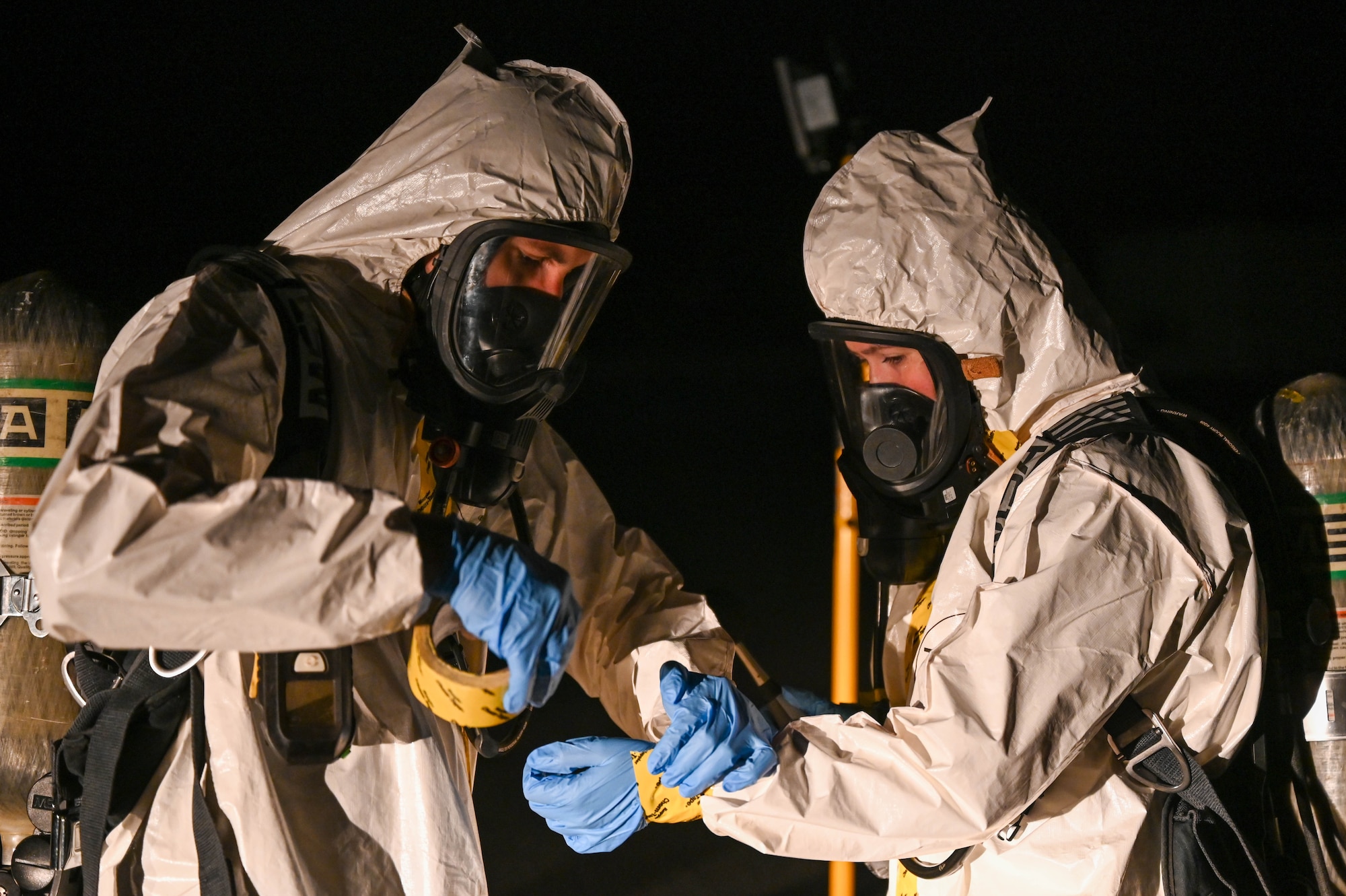 U.S. Air Force 2nd Lt. Austin Pero, 45th Operational Medical Readiness Squadron chief, occupational health element begins to tape all openings on a Chemical-resistant suit worn by U.S. Air Force Senior Airman Samantha Fox, Operational Medical Readiness Squadron bioenvironmental engineering technician on March 14, 2023 at Cape Canaveral Space Force Station, Fla. All openings are sealed so no potential chemicals can harm the wearer. (U.S. Space Force photo by Senior Airman Samuel Becker)