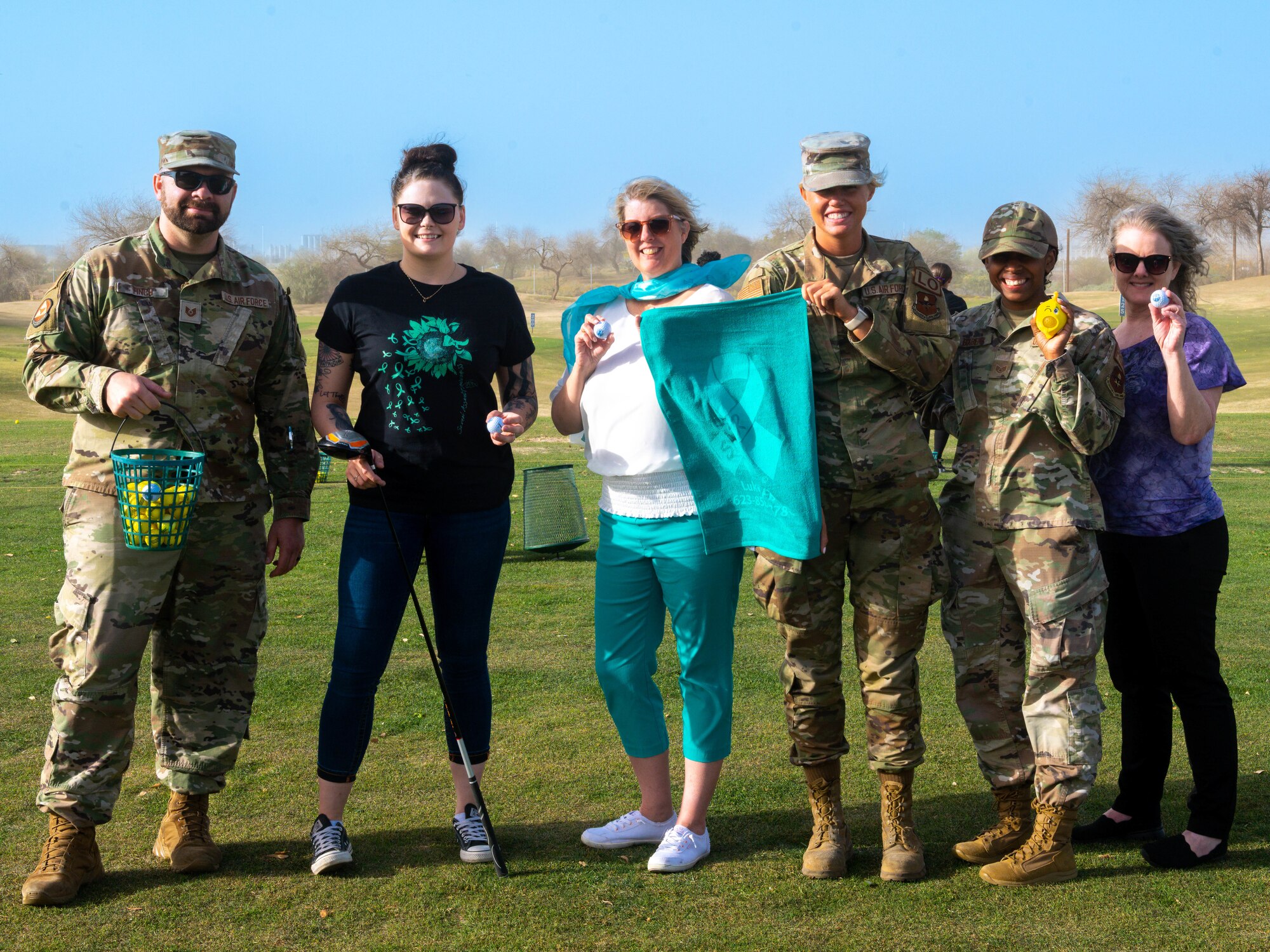 Members of the Luke Air Force Base Sexual Assault Prevention and Response office pose in front of the driving range April 3, 2023, at Falcon Dunes Golf Course, Glendale, Arizona.
