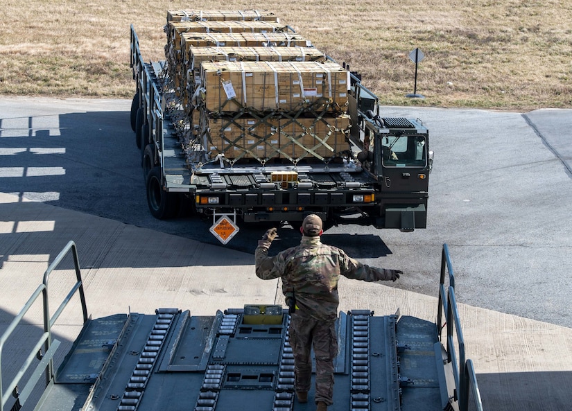 An airman directs supply vehicle.