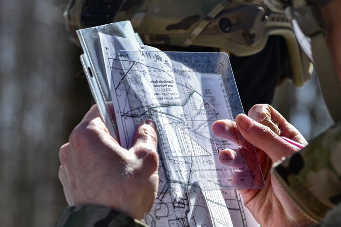 Airman 1st Class Devon Aziz, a fireteam member assigned to the 459th Security Forces Squadron, Joint Base Andrews, Maryland, uses land navigation tools to calculate distance on March 15, 2023, at Camp James A. Garfield Joint Military Training Center, Ohio.