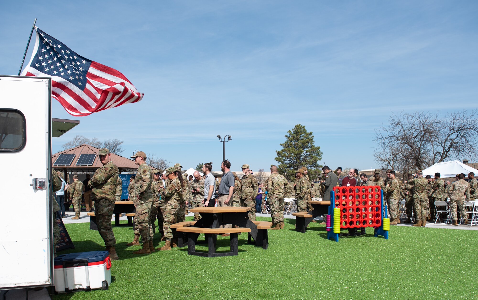 Team McConnell Airmen wait in line to order food at the grand opening for the food truck park at McConnell Air Force Base, Kansas, April 4, 2023. The food truck park provides a variety of easily accessible food for Team McConnell servicemembers. The area was designated a no hat, no salute area for the grand opening. (U.S. Air Force photo by Staff Sgt. Tryphena Mayhugh)