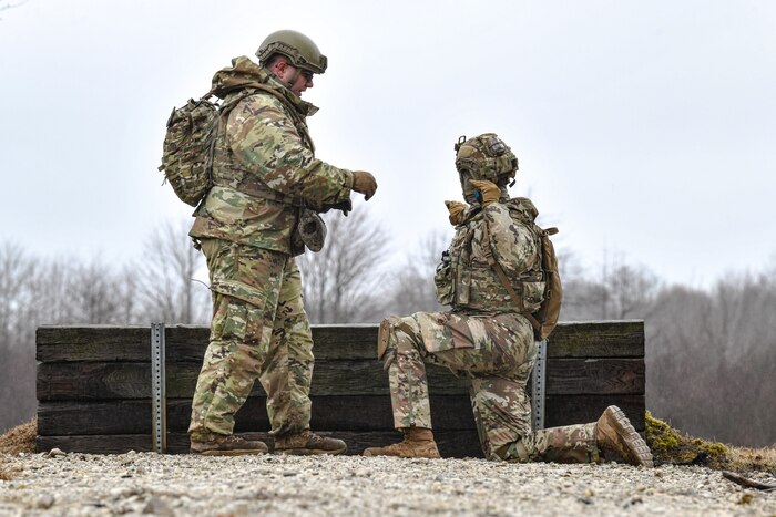 Tech. Sgt. Allen Russell, an Integrated Defense Leadership Course cadre member assigned to the 910th Security Forces Squadron, Youngstown Air Reserve Station, Ohio, hands off a practice grenade to an IDLC student on March 17, 2023, at Camp James A. Garfield Joint Military Training Center, Ohio.