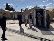 People enter the Patriot Cafe in a field kitchen.