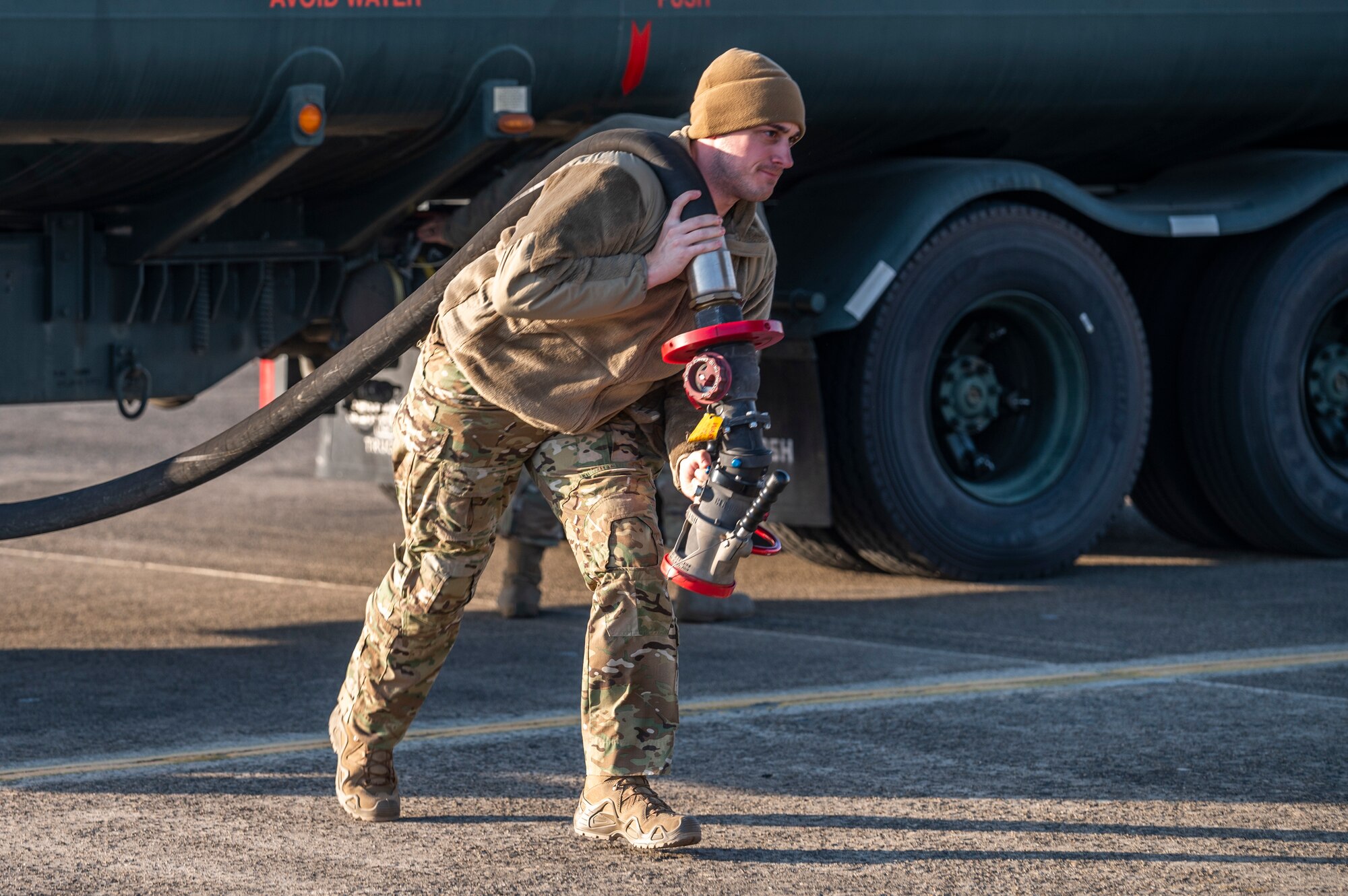 A U.S. Airman assigned to the 353rd Special Operations Aircraft Maintenance Squadron carries a hose to refuel an MC-130J Commando II during Freedom Shield 23 at Daegu Air Base, Republic of Korea, Mar. 14, 2023.