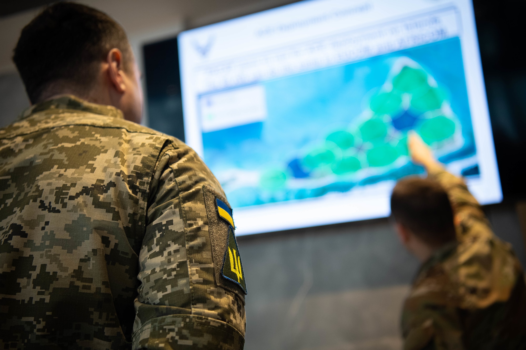 U.S. Air Force Senior Airman Thomas Kozub, right, 355th Comptroller Squadron financial analyst, explains to Chief Master Sgt. of the Air Force of the Armed Forces of Ukraine Kostiantyn Stanislavchuk about mesh networking capabilities in an Agile Combat Employment environment at the Hercules Innovation Lab at Ramstein Air Base, Germany, March 8, 2023. Chief Stanislavchuk visited various USAF education and training institutions around the Kaiserslautern military community to discuss future education and training opportunities for Ukrainian Armed Forces non-commissioned officer corps. (U.S. Air Force photo by Airman 1st Class Jared Lovett)