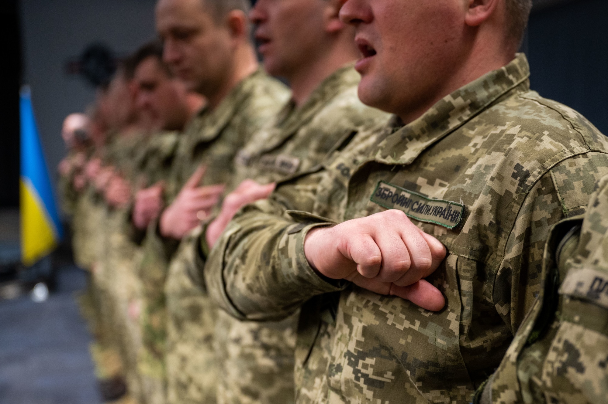 Ukrainian Air Force members sing along to their national anthem at the Inter-European Air Force Academy at Kapaun Air Station, Germany, March 16, 2023. IEAFA’s professional military education is a combined experience with students from Squadron Officer School and Noncommissioned Officer Academy learning alongside one another. (U.S. Air Force photo by Tech. Sgt. Steven Adkins)