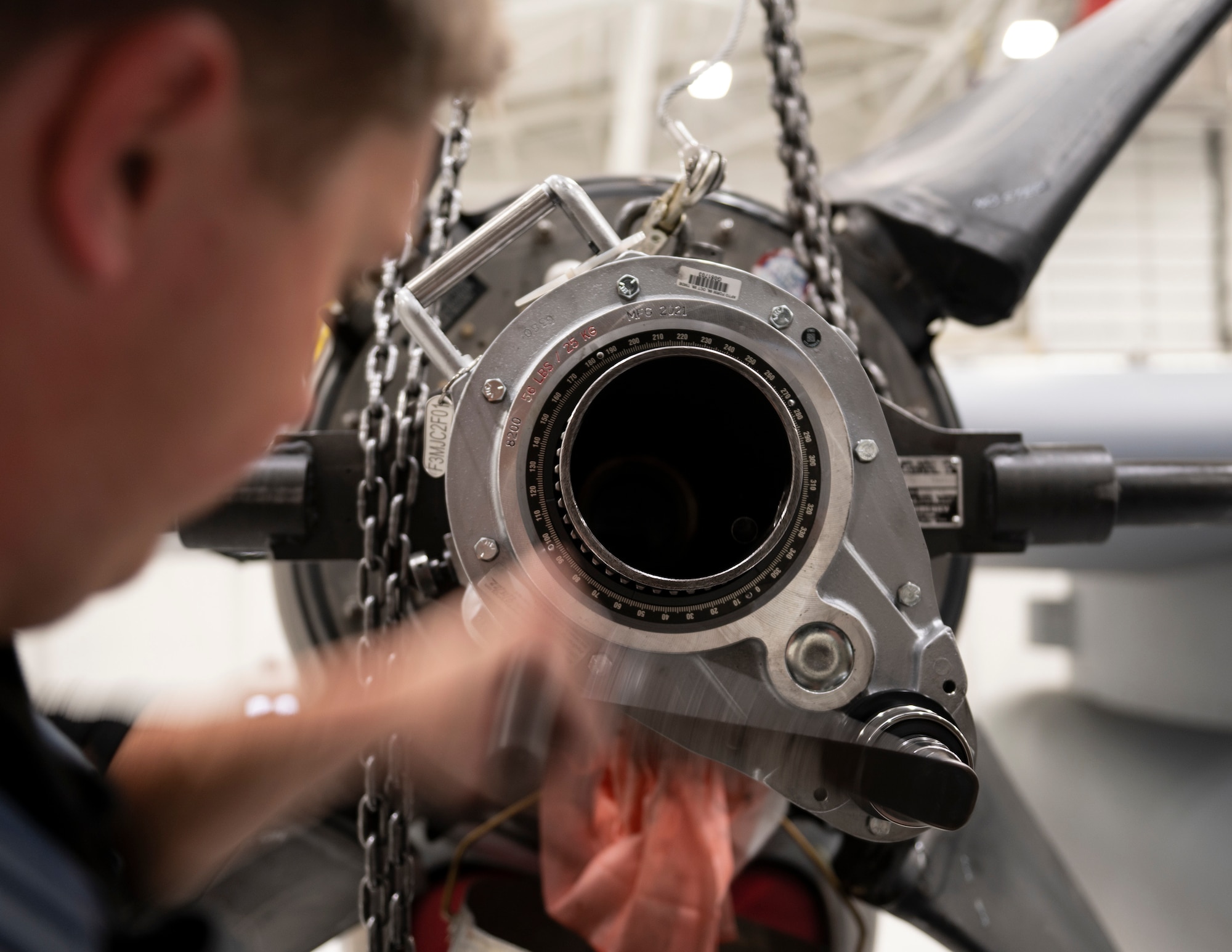 U.S. Air Force Airman 1st Class Jesse Carlson, propulsion mechanic, 133rd Maintenance Squadron, loosens up the giant hub nut inside the propeller in St. Paul, Minn., Oct. 24, 2022.