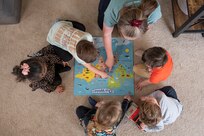 Joint Base Anacostia-Bolling Family Child Care provider, Amanda Wade, completes a puzzle with children in her home on March 31, 2023, at JBAB, Washington, D.C. FCC providers care for children in the provider’s home, which increases child care capacity for the JBAB community while simultaneously creating work-from-home employment opportunities. (U.S. Air Force photo by Jason Treffry)