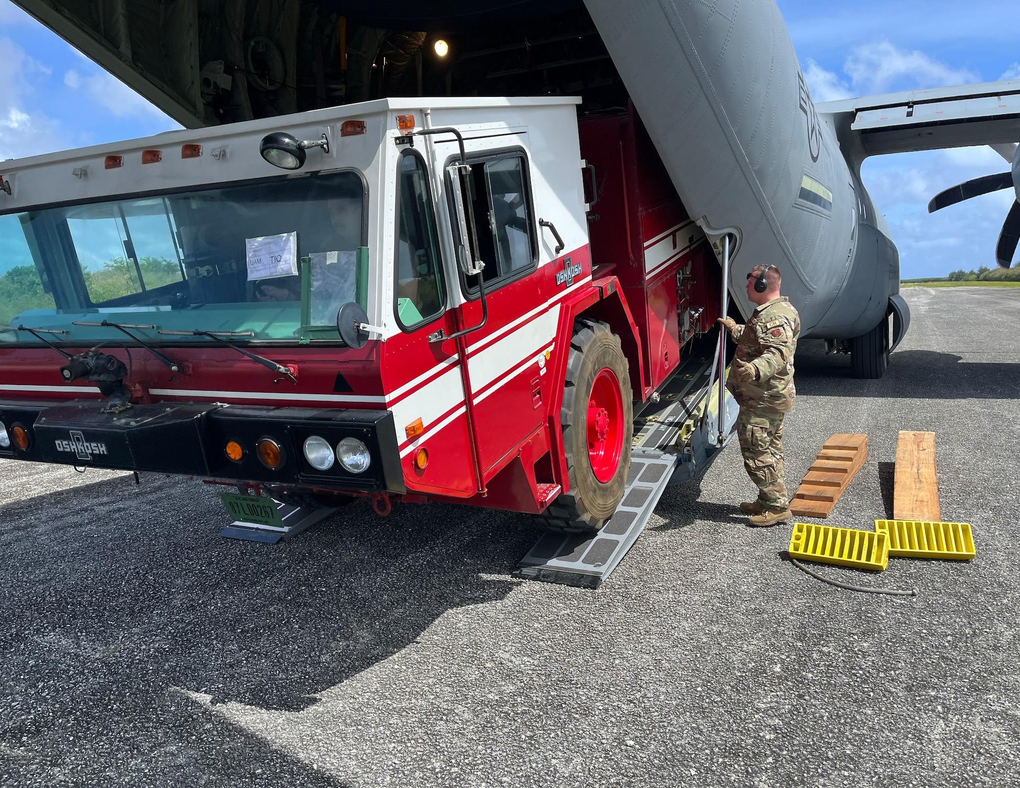 U.S. Air Force Tech. Sgt. Micheal Schuette, 133rd Contingency Response Team, downloads a fire truck from a C-130 Hercules in the Commonwealth of the Northern Marianas Islands, Feb. 13, 2023.