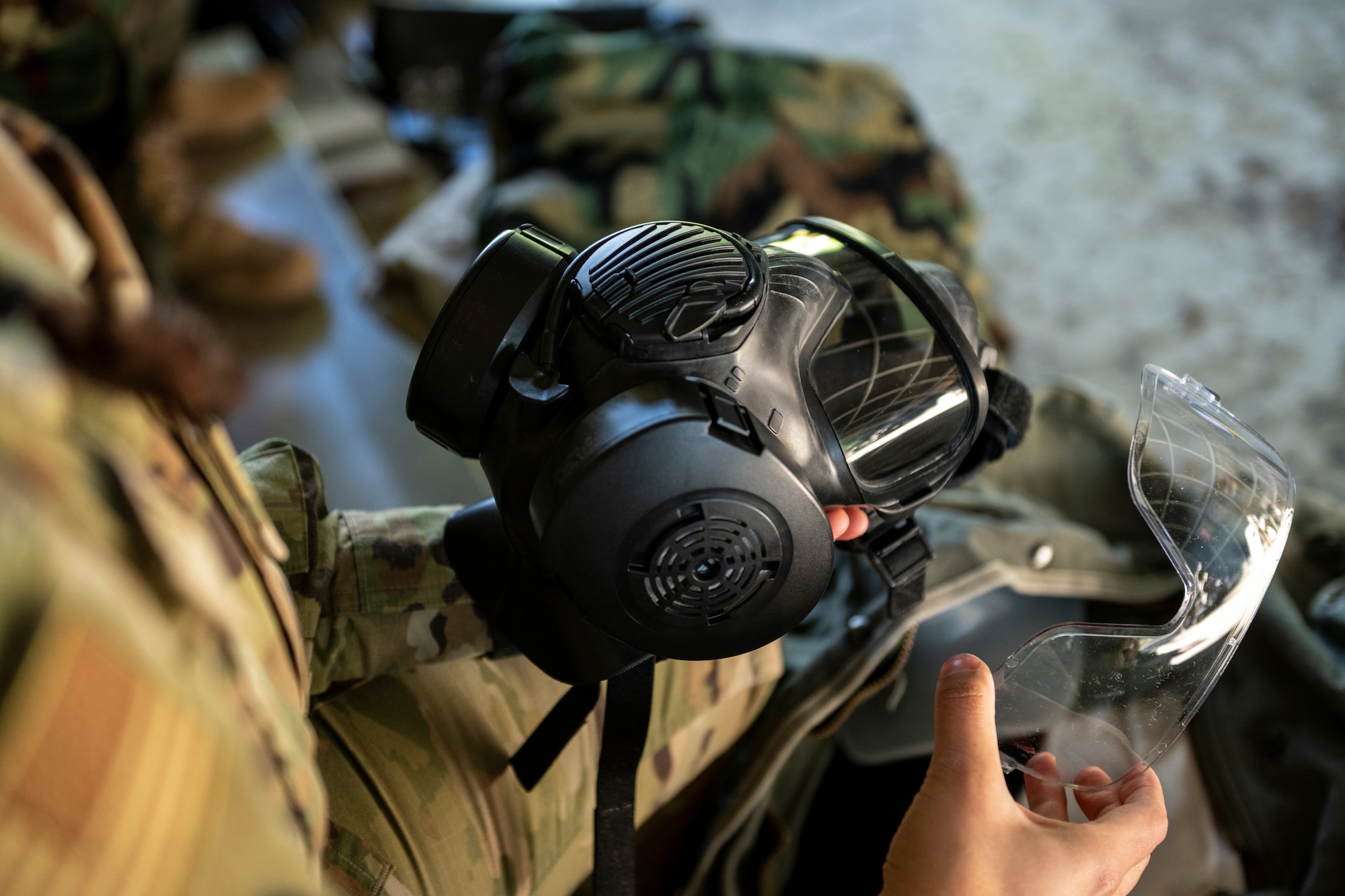A U.S. Air Force Airman assigned to the 23rd Wing, inspects her gas mask