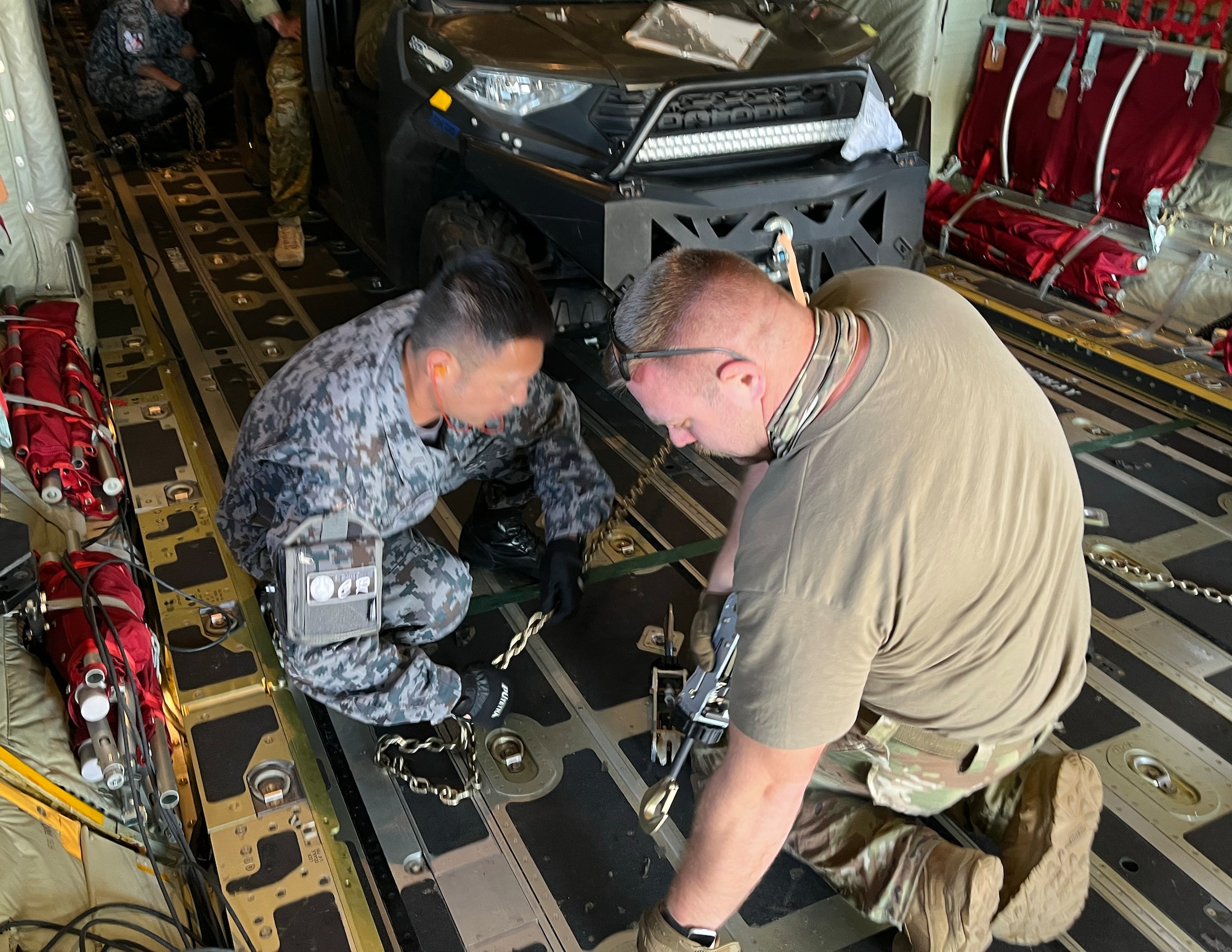 U.S. Air Force Tech. Sgt. Michael Schuette, 133rd Contingency Response Team, works with other contingency response members from Japan to offload a UTV in the Commonwealth of the Northern Marianas Islands, Feb. 13, 2023.