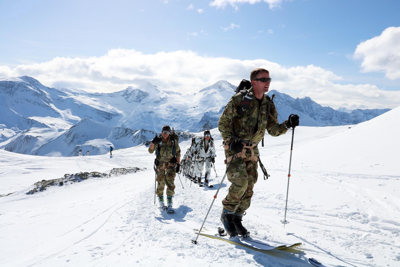 An Army skier moves past a line of foreign skiers.