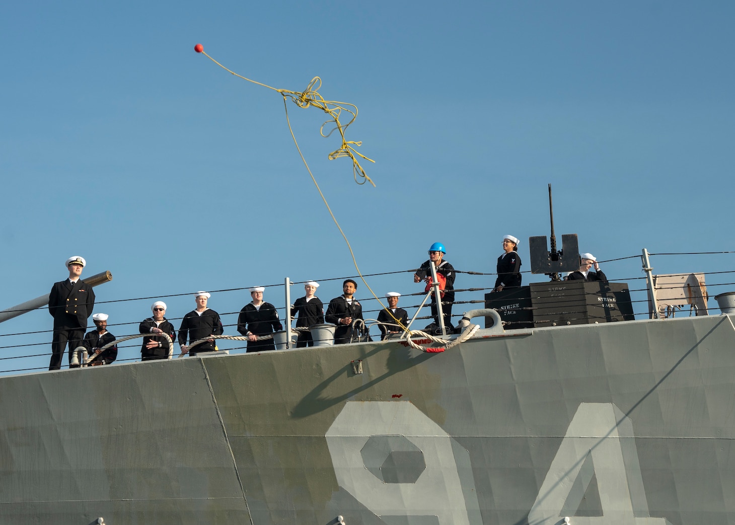 A Sailor aboard the guided-missile destroyer USS Nitze (DDG 94) throws a messenger line to the pier as Nitze arrives at Naval Station Norfolk after a scheduled deployment April 5, 2023.