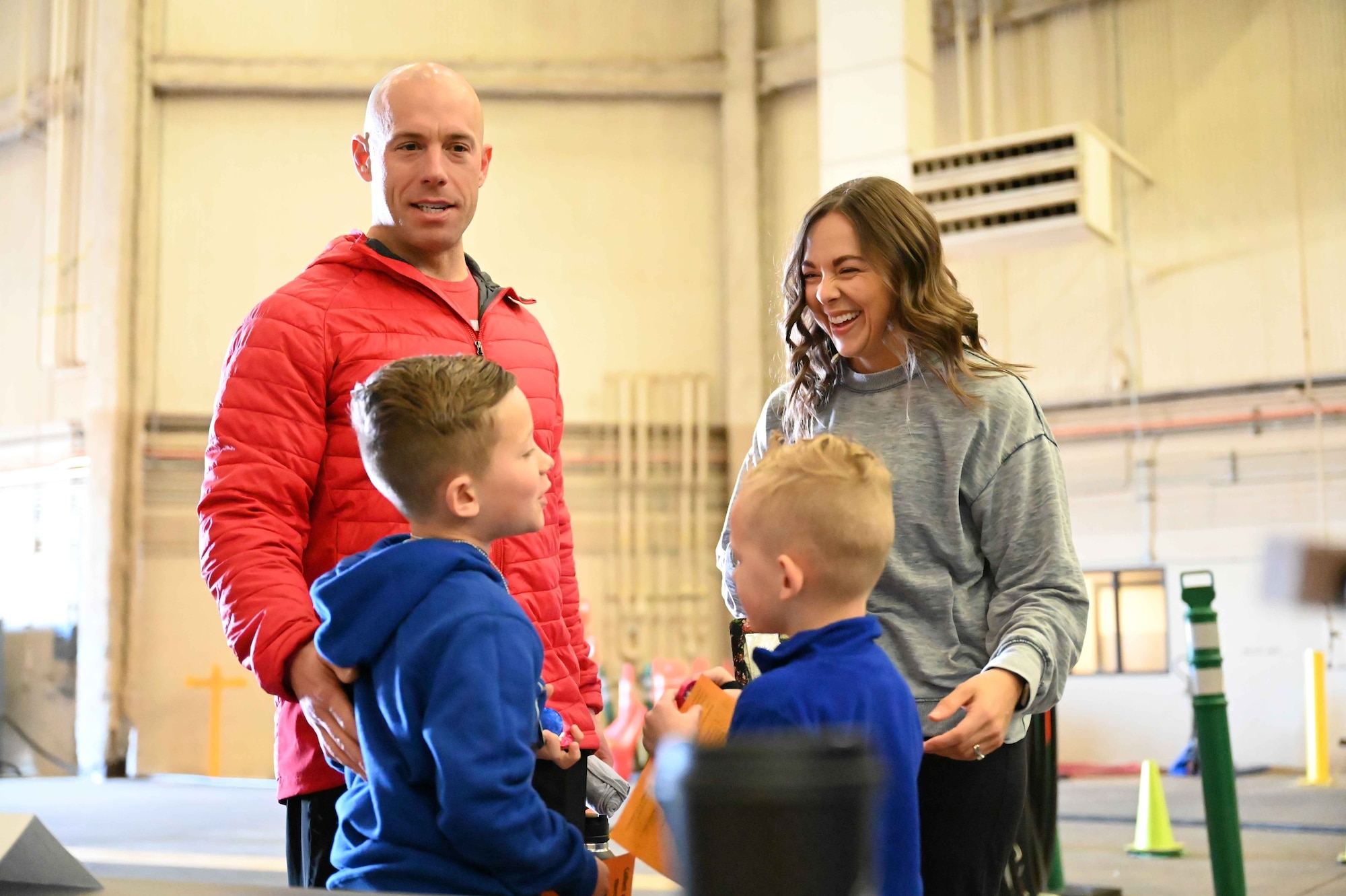 A military family laughs together during the “Kid’s Deployment Line” at Altus Air Force Base, Oklahoma, April 1, 2023. The event gave children an opportunity to see what their parents go through during a real deployment line. (U.S. Air Force photo by Airman 1st Class Kari Degraffenreed)