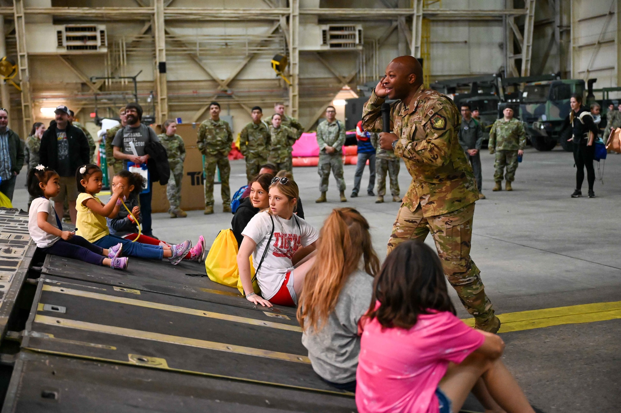 U.S. Air Force Col. Patrick Brady-Lee, 97th Air Mobility Wing vice commander, waits for an answer while talking to children of service members during the “Kid’s Deployment Line” at Altus Air Force Base, Oklahoma, April 1, 2023. Brady-Lee encouraged the children to be proud of their status as military children, especially during April, which is known as “The Month of the Military Child” across the Department of Defense. (U.S. Air Force photo by Airman 1st Class Kari Degraffenreed)